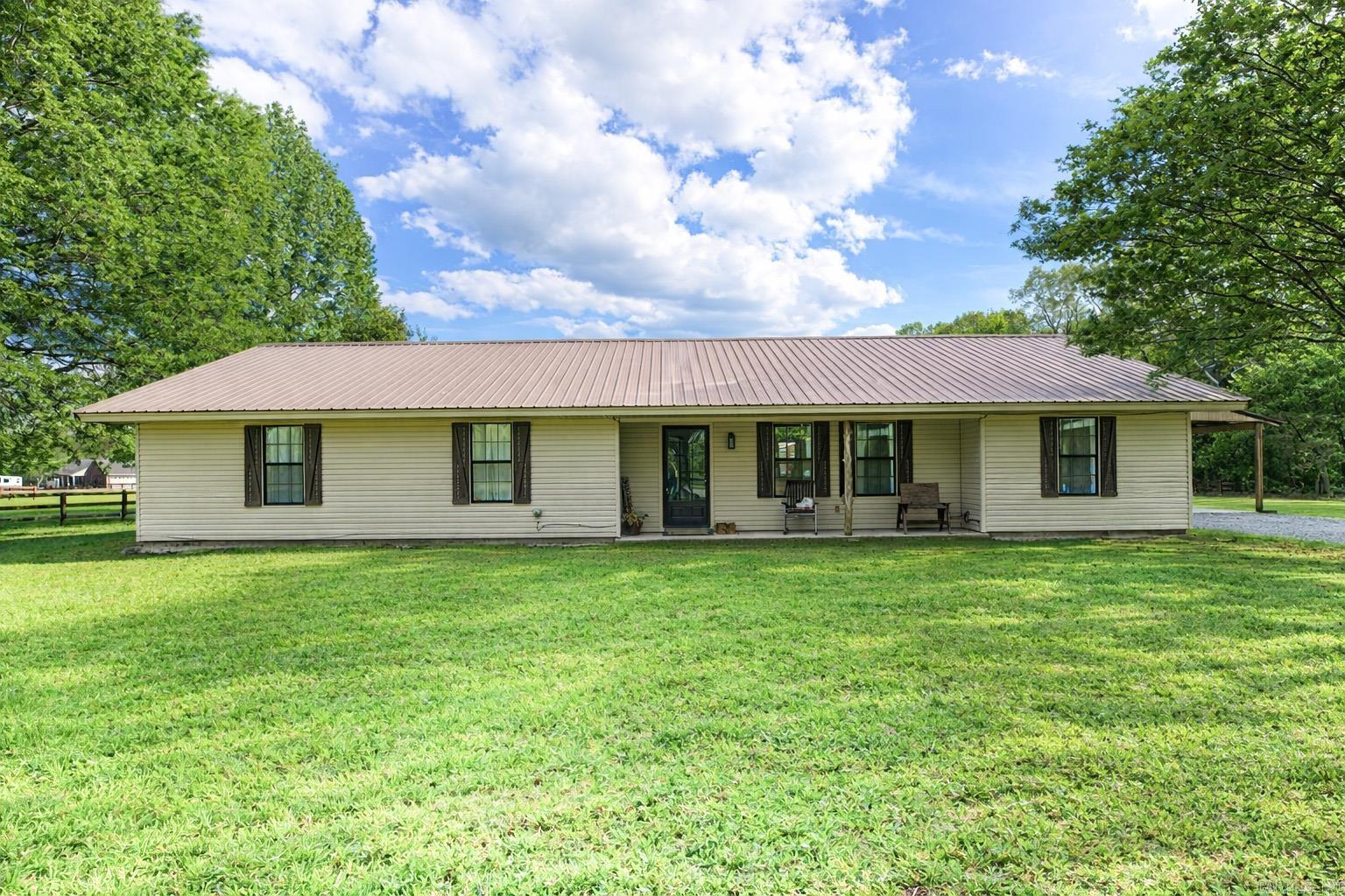 Welcome to peaceful country living on 1.89 acres at the end of a quiet dead-end road- AND A SHOP! Located in White Hall School District, this beautifully updated 4-bedroom, 2-bathroom home has so much to offer with a great layout and modern updates! Step inside to find new flooring and fresh paint, creating a clean and inviting atmosphere. The remodeled farmhouse-style kitchen features a breakfast bar, updated finishes, and plenty of space for gathering. A dedicated laundry room includes custom built-in cubbies and is accented by a stylish sliding barn door for added character. Enjoy outdoor living year-round on the extended back patio, complete with a wood-paneled ceiling and mounted TV—perfect for entertaining or relaxing evenings at home. The property also boasts beautiful landscaping and a durable metal roof. Need space for hobbies or storage? You’ll love the brand-new 30x40 shop, offering endless possibilities. With privacy, modern updates, and room to spread out, this property is a winner! Schedule your showing today!
