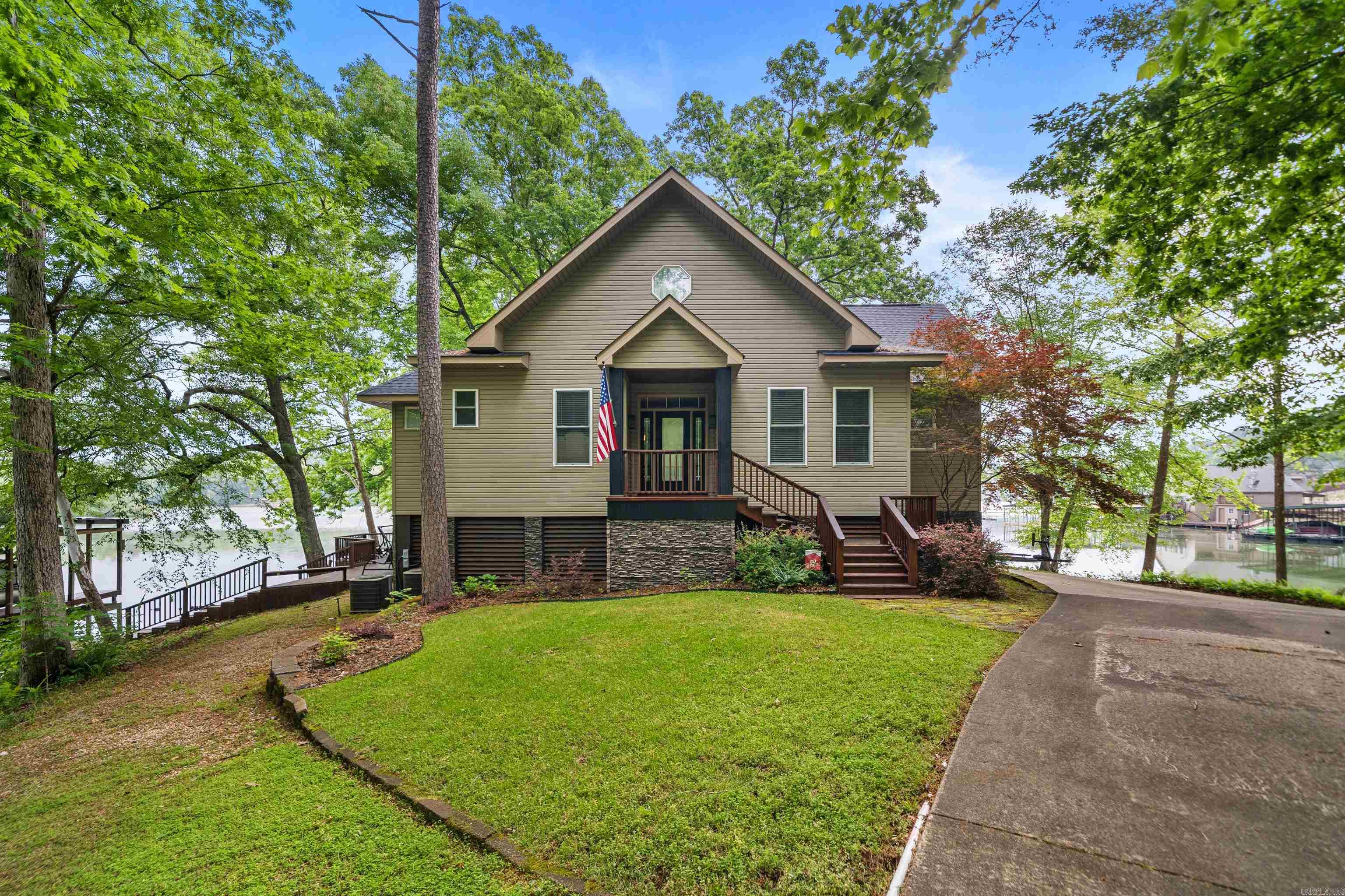 Stunning Point Lot on Lake Catherine with 619 Ft of Shoreline  Rare opportunity to own a premier point property on Lake Catherine with an incredible 619 feet of water frontage, offering expansive views, added privacy, and a true “surrounded by water” lake experience. This beautifully maintained 4-bedroom, 3-bath home is designed for both relaxing and entertaining. The open-concept kitchen features rich wood cabinetry, granite countertops, stainless appliances, and a built-in wine rack, flowing seamlessly into a light-filled dining area with panoramic lake views. Step outside to the oversized covered deck with a warm wood-paneled ceiling—an ideal space for gathering, dining, or simply taking in the peaceful setting. With water visible from multiple angles, this home fully captures the beauty of its unique point location. Situated on a mostly level, tree-shaded lot, the property offers easy access to the shoreline and exceptional outdoor living potential. The combination of privacy, usable land, and expansive waterfront is truly hard to find. If you’ve been searching for a standout lake property with incredible frontage and inviting spaces inside and out, this is it.