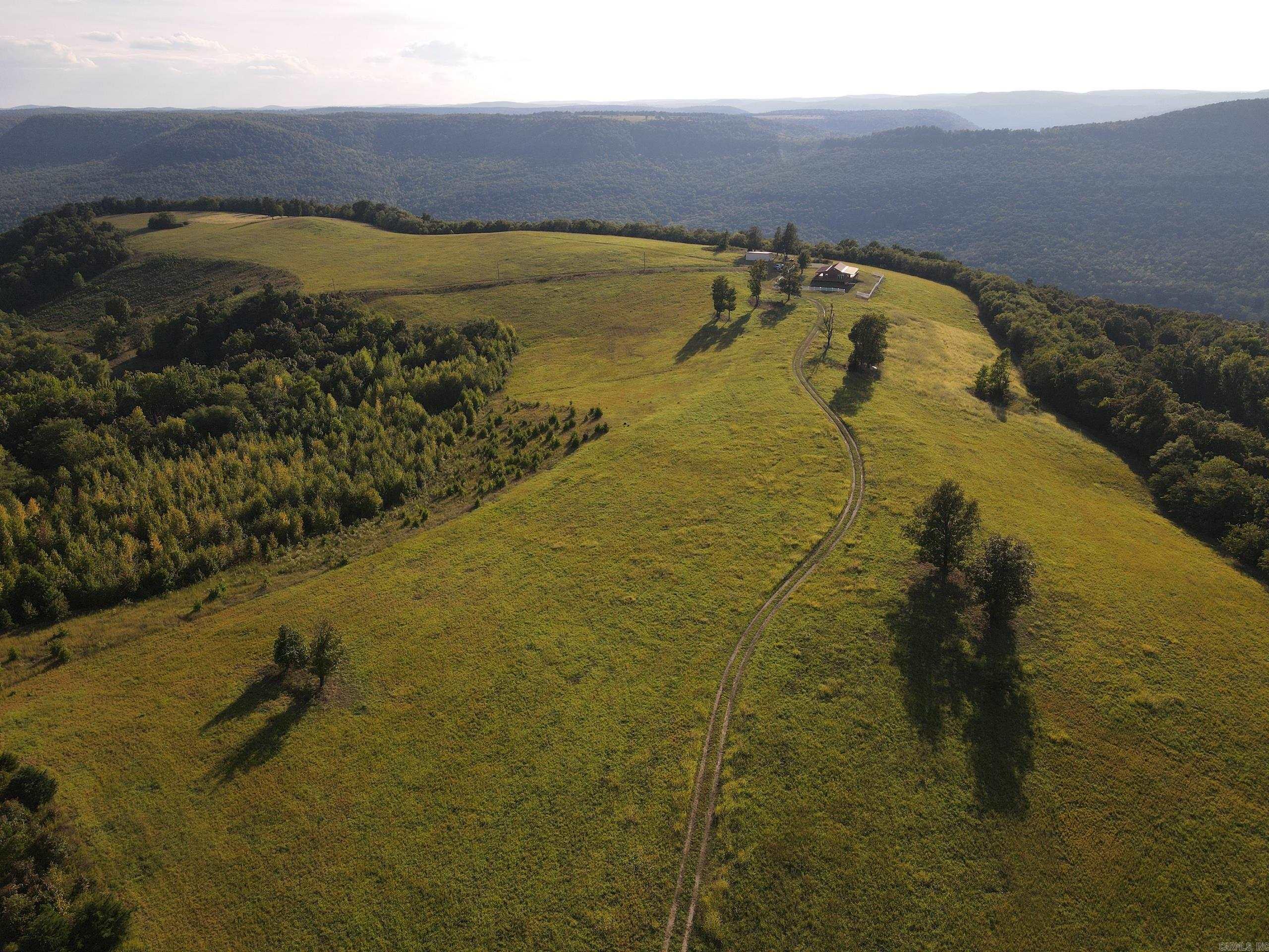 Truly world-class properties are few and far between, and this property is no less than that. Decades of care, management, memories, heart, and soul have gone into this amazing slice of heaven. Setting atop a mountain overlooking the famous Calf Creek Valley near Snowball, AR, this tract has so many assets you just have to see to believe. The region is loaded with wildlife and is renowned for the giant bull elk, massive whitetail bucks, and huge black bear… and they all call this tract home as well! You can't duplicate this location just south of the Buffalo National River and the coveted Richland Creek Valley. The lodge is situated near the county road but is also very private and secluded, overlooking one of the most breathtaking vista views you will find in the state. The wrap-around porch lets you observe both views of the rolling topography of the land but also sports views of the valleys to the West and North. You can literally watch the horizon disappear and see until you simply can't anymore. The spacious lodge has an open floor plan with the living/dining/kitchen all giving you a view through massive windows, inviting the natural light and infinite view into the lodge.