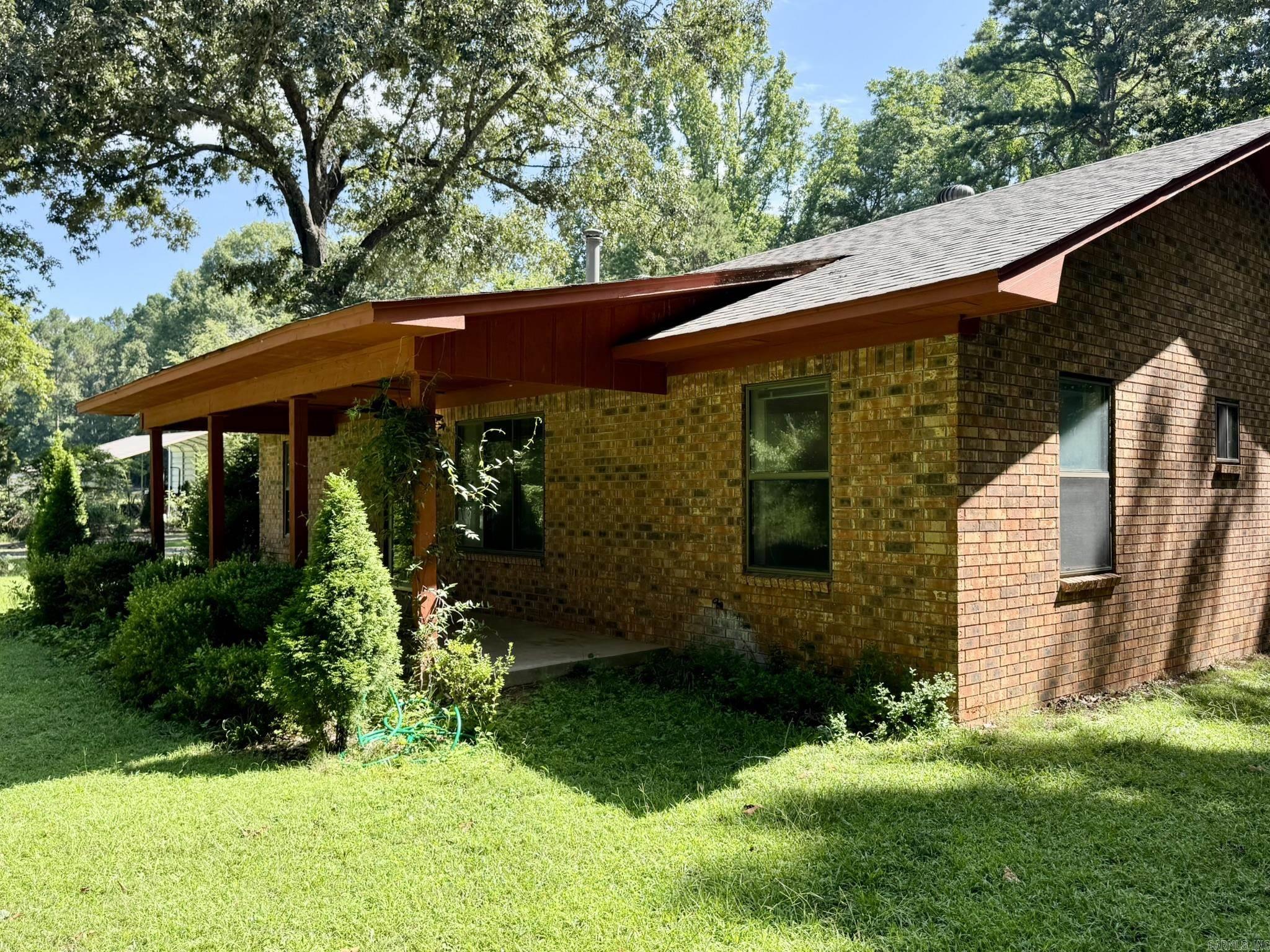 Your own wooded retreat, just minutes from Little Rock. Tucked at the end of a long paved drive, this 3 bedroom, 2 bath brick home offers approximately 2 acres of privacy, mature trees, frequent wildlife, and room to breathe, all about 8 miles from I-430 and convenient to major medical centers, employers, shopping, and dining. Inside, the generous one-level floor plan makes excellent use of the space, with a large living room centered around a wood-burning stove, separate dining area, roomy kitchen, oversized utility room, and minimal wasted hallway space. A recently updated roof, covered front porch, fenced backyard, and detached storage building add practical value. The interior retains a few older finishes, and offers a solid opportunity to personalize while enjoying the acreage, peaceful surroundings, and everyday convenience from day one.