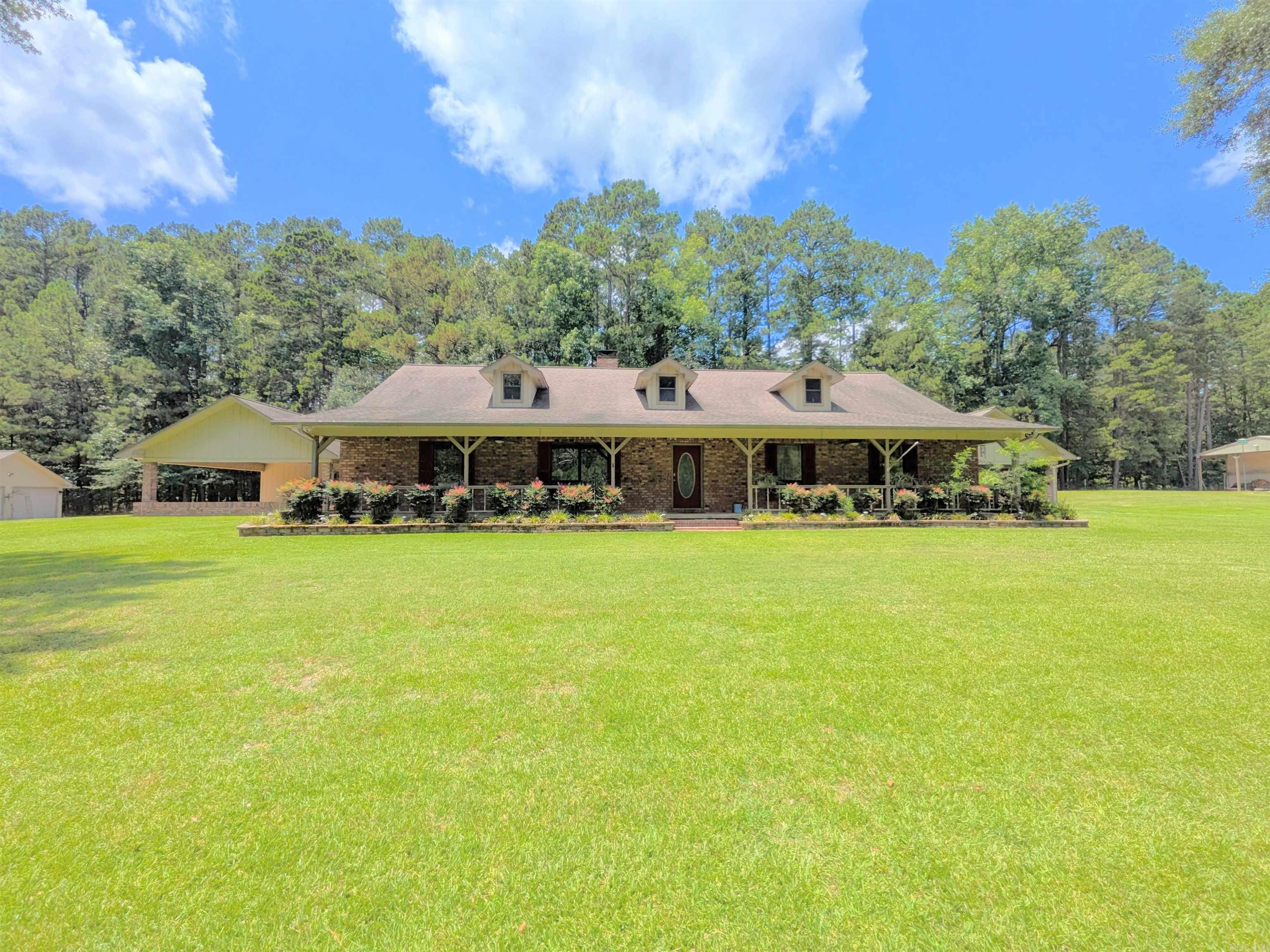 This 4 BR/2 BA ranch-style brick home offers 2,376 sqft of space, situated on a 3-acre (M/L) lot just outside Camden city limits. Enjoy the convenience of city water, natural gas, underground utilities, & ARIS internet. Inside, you'll find hardwood & tile flooring, custom cabinetry, built-ins, & quartz countertops. The thoughtfully-designed kitchen also features a pantry w/ drawers & a workspace/desk area. A bonus room provides the option for a 4th bedroom, office, or media room. The living room boasts a vaulted ceiling & a woodburning fireplace w/ insert, while the master suite includes a 3'x6' walk-in shower & double closets. This property truly shines outdoors w/ a fully-equipped outdoor kitchen featuring stainless steel cabinets, an 8-ft hot tub, TV, & dining bar. The landscaped grounds include a patio/breezeway, sprinkler system, greenhouse, small pond, & multiple outbuildings - a 24x40 heated/cooled shop w/ half bath & attic, a 30x60 pole barn, & additional storage. A three-car attached garage w/ floored attic provides even more storage. Additional acres are also available for future purchase. Square footage, lot size, and acreage is taken from courthouse records.