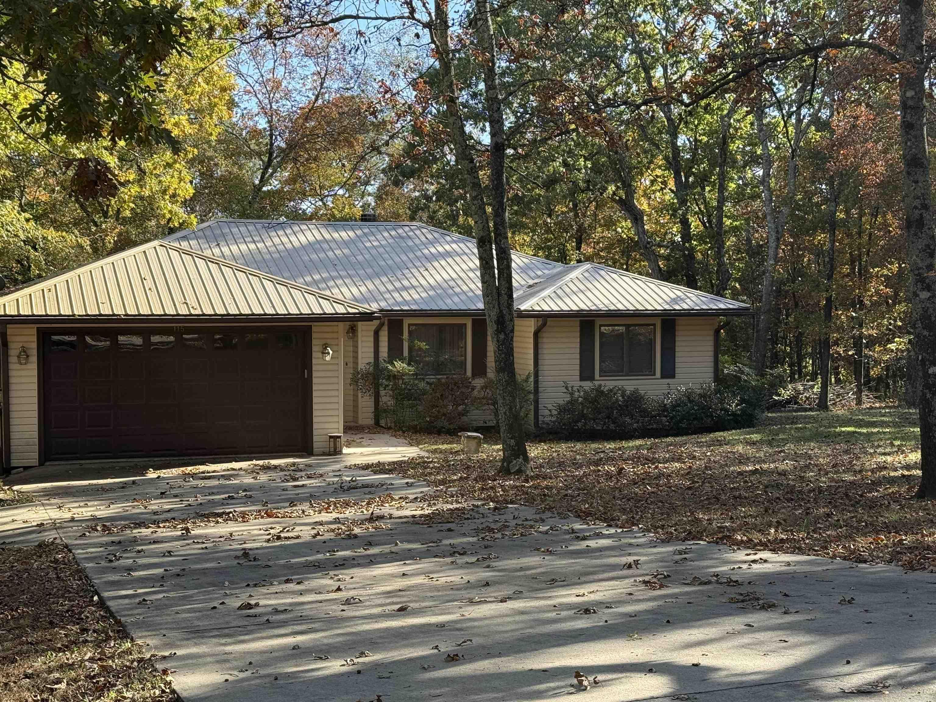 CASUAL COMFORT and elbow room with this custom home on 3 lots (2 replatted).  Great layout in the floorplan provides private areas as well as expanded space for entertaining.  The living-dining area has a corner fireplace, plus built-in cabinets.  The central kitchen has an adjoining breakfast room or hobby focus with lots of storage, and has a full view of the outdoor natural setting.  This would be a great studio or office.  Three BR, two baths are on the opposite end of the house.  A large sunroom is located at the back of the house, with walls of windows that look out to the wooded yard.  Listen for the creek and waterfalls after a good rain! Just sit on the back deck and soak up some nature.   In the basement level, you'll have area for your shop and extra storage.  Additionally, a roomy carport will house a motorhome or small RV, plus storage room.  Furniture is negotiable.