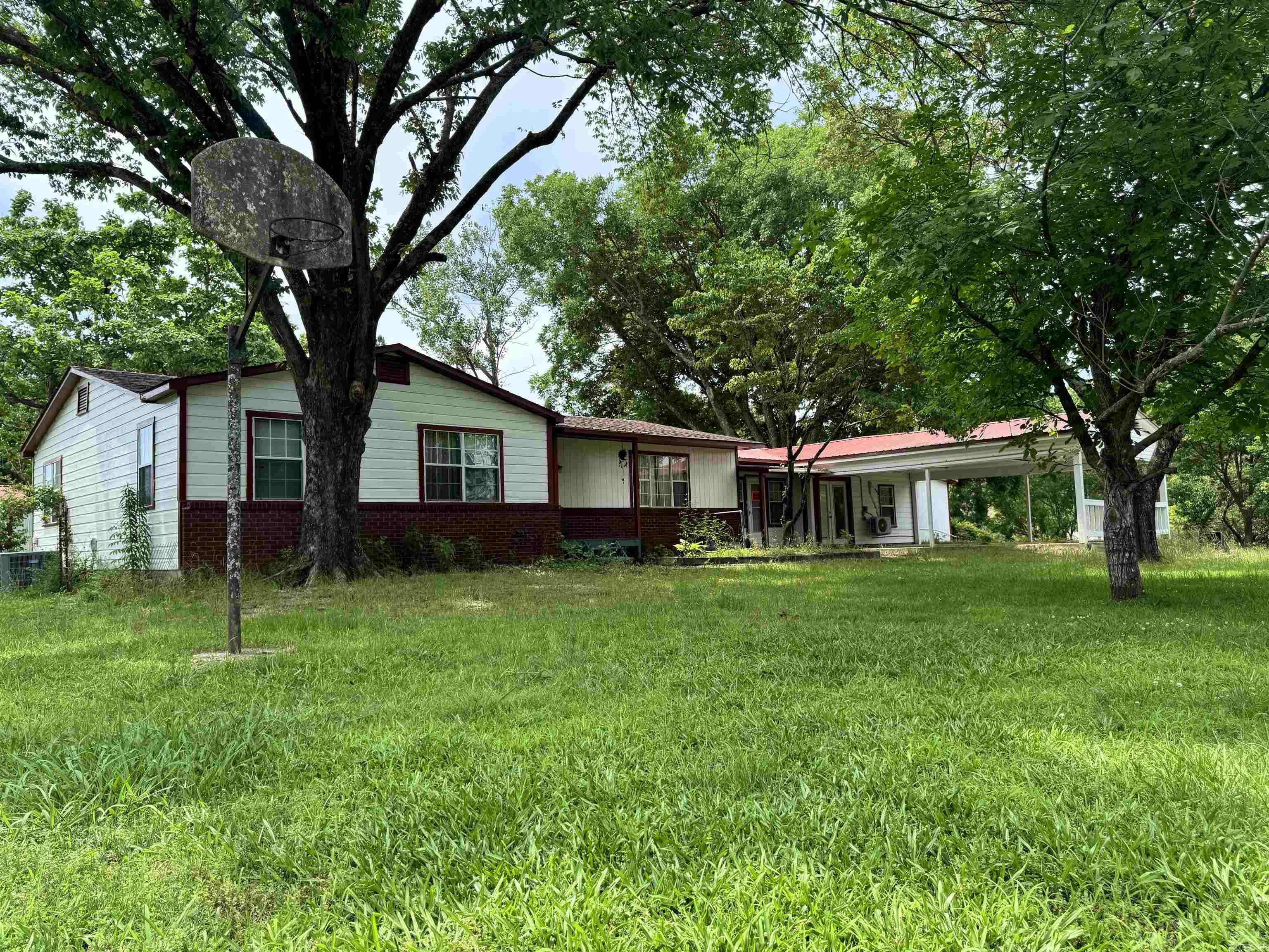 This 10-acre property in Wickes, Arkansas offers a rare mix of space, convenience, and functionality with highway frontage and a wide range of features for country living. The 4-bedroom home includes 1 full bath and 2 half baths, providing ample room for family or guests.  Outdoors, you'll find multiple established gardening areas with producing blackberry and blueberry bushes, as well as fruit trees already bearing. A greenhouse extends your growing season, and a covered barn adds flexibility for equipment, storage, or livestock use. The property also includes two outdoor storage areas and two separate sheds—one of which has electricity, and an electric vehicle charger.  A large shop is fully equipped with water, electricity, a wood-burning stove, and its own bathroom, ideal for projects, hobbies, or workspace needs. There's also a chicken coop with electricity and water, a storm shelter for added safety, and an existing well (currently not in use).  With easy access off the highway and a well-thought-out layout, this property offers both practicality and room to grow. SELLER WILL PAY UP TO $5,000 IN BUYER CLOSING COSTS.