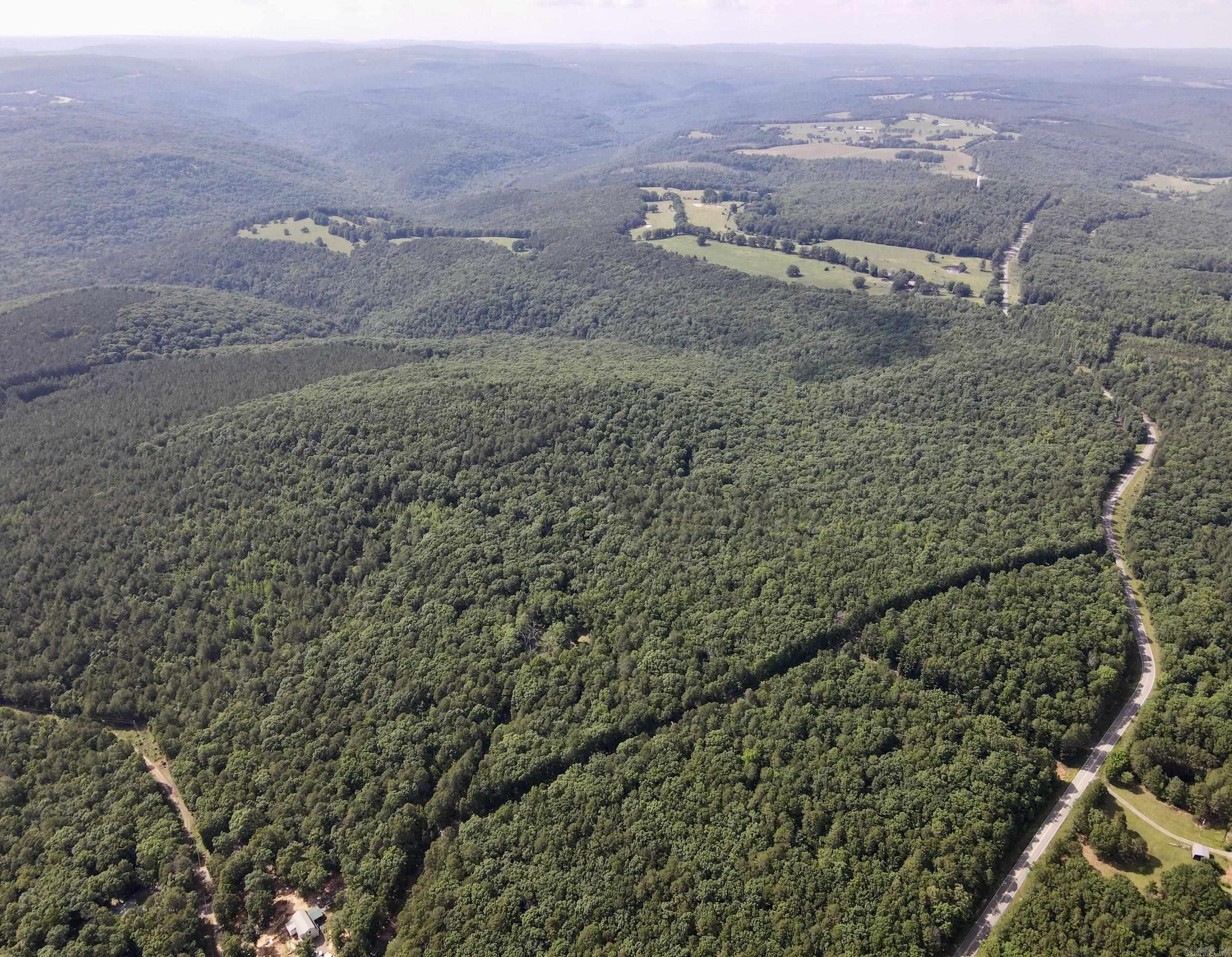 A gated entrance and established internal road system provide excellent access throughout. The property consists of two parcels connected by a deeded easement, allowing the front parcel to serve as a homesite while the back parcel remains a private recreational retreat.  The gently rolling terrain features multiple potential building sites and panoramic Ozark Mountain views. A healthy stand of mature Red Oak, White Oak, and Shortleaf Pine provides quality wildlife habitat and future timber income potential.  Abundant whitetail deer, wild turkey, and black bear make this an outstanding hunting and recreational property. Ideal for a homesite, hunting retreat, family getaway, or long-term investment.
