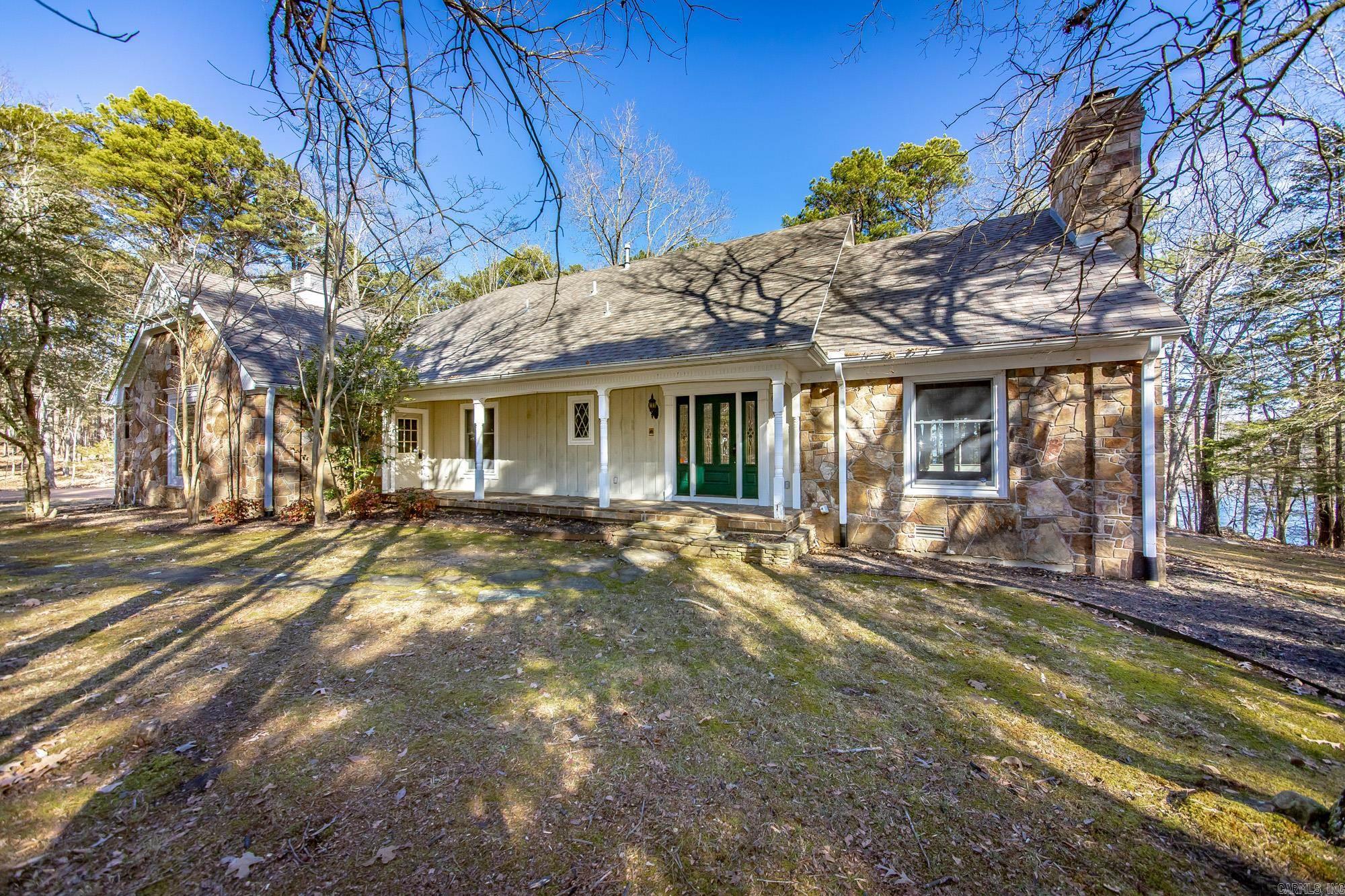 MOTIVATED SELLER This well-constructed lakefront home offers a rare chance to own on Greers Ferry Lake in the desirable Grand Isle area. A boat slip is available nearby for $35,000, making lake days effortless & convenient. Rendered photos are included to illustrate potential updates and demonstrate how easily this property could be transformed into a spectacular lakeside retreat. Tucked away in a private setting, Grand Isle is known for its peaceful atmosphere & is ideal for walking, biking, & enjoying the natural surroundings. The home features a spacious screened-in porch and a large patio, perfect for relaxing on summer evenings while overlooking the lake. An oversized garage provides ample space for boats, golf carts, and all your lake toys. Inside, the home offers two comfortable dens, creating warm and inviting spaces to gather on cooler nights. The layout provides excellent potential, with the kitchen easily opened up to create a more modern, open-concept design. This home is ready for a facelift and offers endless possibilities to make it truly special. Lakefront homes of this quality at this price point are rarely available and is being offered well below appraised value.