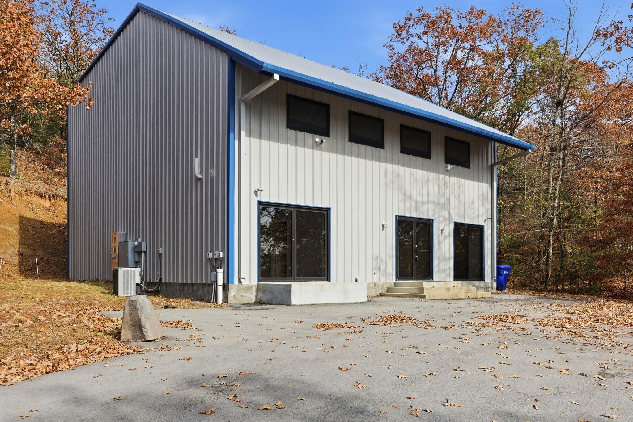 Versatile owner-user or investment opportunity in a fast-growing Conway corridor. This well-maintained 2,000 SF flex/industrial building sits on a 1-acre lot and features rare RU-1 (Industrial) zoning, allowing for a wide range of commercial and light industrial uses. The property is equipped for high-performance operations, previously used as a solar data center and TV production recording studio. Infrastructure includes 600A / 240V electrical service, Conway Corp electric service with low commercial rates, Conway Corp fiber broadband, and a recently upgraded municipal water connection. An on-site septic system is in place. Interior features include two built-out office spaces, a restroom, and an open warehouse area. Approximately 600 SF of additional floored, unfinished space is available for a potential second-story expansion, with new windows already installed. Recent upgrades include a newly paved driveway and parking area, new warehouse windows providing natural light, and energy-efficient LED lighting throughout. Located within Conway city limits along the developing Lower Ridge Road corridor. This property offers flexibility, strong infrastructure and growth potential.