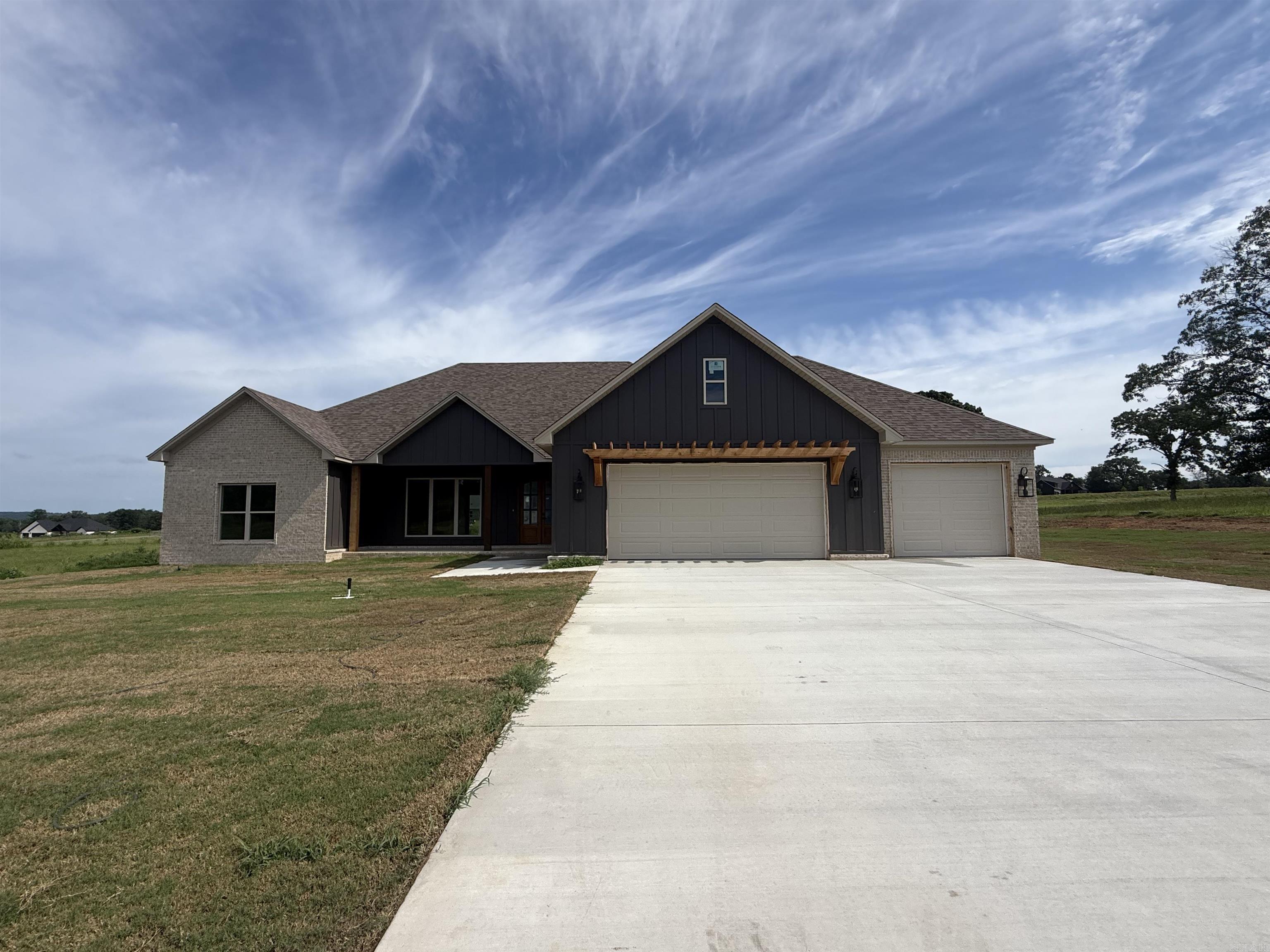 Welcome to this beautiful new construction home set on a spacious 1-acre lot. This thoughtfully designed 4-bedroom, 2.5-bath home features an inviting open-concept layout perfect for both everyday living and entertaining. The living area flows seamlessly into a stunning kitchen with custom cabinetry, a large island, and plenty of workspace. Enjoy natural light throughout, highlighted by expansive sliding glass doors leading to a covered back porch—ideal for relaxing or hosting guests.  The exterior showcases a timeless blend of brick and modern accents, complemented by a welcoming front porch. Inside, you’ll find quality craftsmanship, stylish finishes, and a functional split-bedroom floor plan offering privacy and comfort. The generous lot provides ample space for outdoor activities, future additions, or simply enjoying the peaceful surroundings.  Don’t miss the opportunity to own this brand-new home with modern design and room to grow!