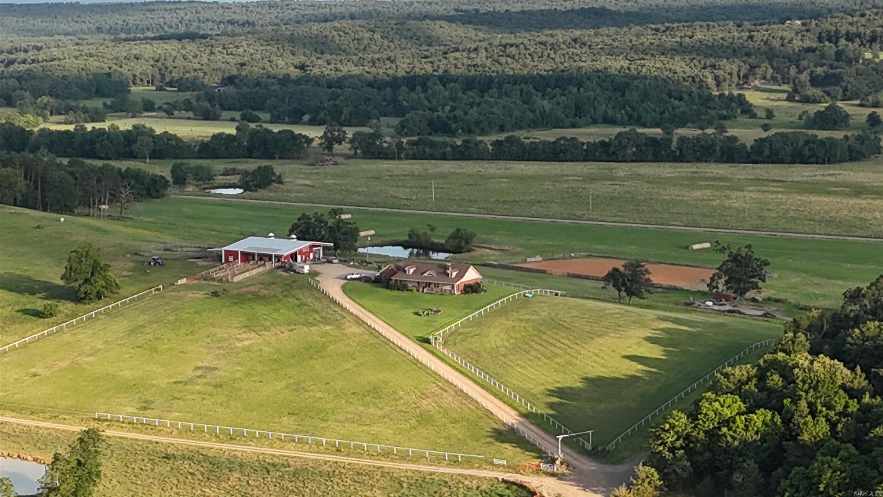 Midwest Land Group is pleased to present the Mossy Rock Ranch. Situated approximately 3.6 miles east of Scranton, this property encompasses 44+/- acres of scenic hilltop terrain. The property encompasses four enclosed paddocks, notably including a 14+/- acre meadow that has been diligently preserved for hay cultivation and is equipped with a pond.. Equipped with a professional roping and barrel racing arena and an expansive 80x100 horse barn featuring four turnouts, the ranch is fully prepared to accommodate equestrian activities.    The barn facility is fully plumbed and prepared for the installation of a bathroom. The loft area situated above the turnouts was specifically engineered to house a capacity of up to 1,000 square hay bales. The structure further includes a 20-foot shed extension at the rear, a dedicated sorting lot, and a sophisticated tack room located in the northeast corner. Additionally, four roll-up garage doors have been integrated to ensure efficient access to the premises. The property further includes a 40x60 concrete foundation equipped with electrical service, providing a prepared site for the construction of an additional workshop.  The driveway, yard, and