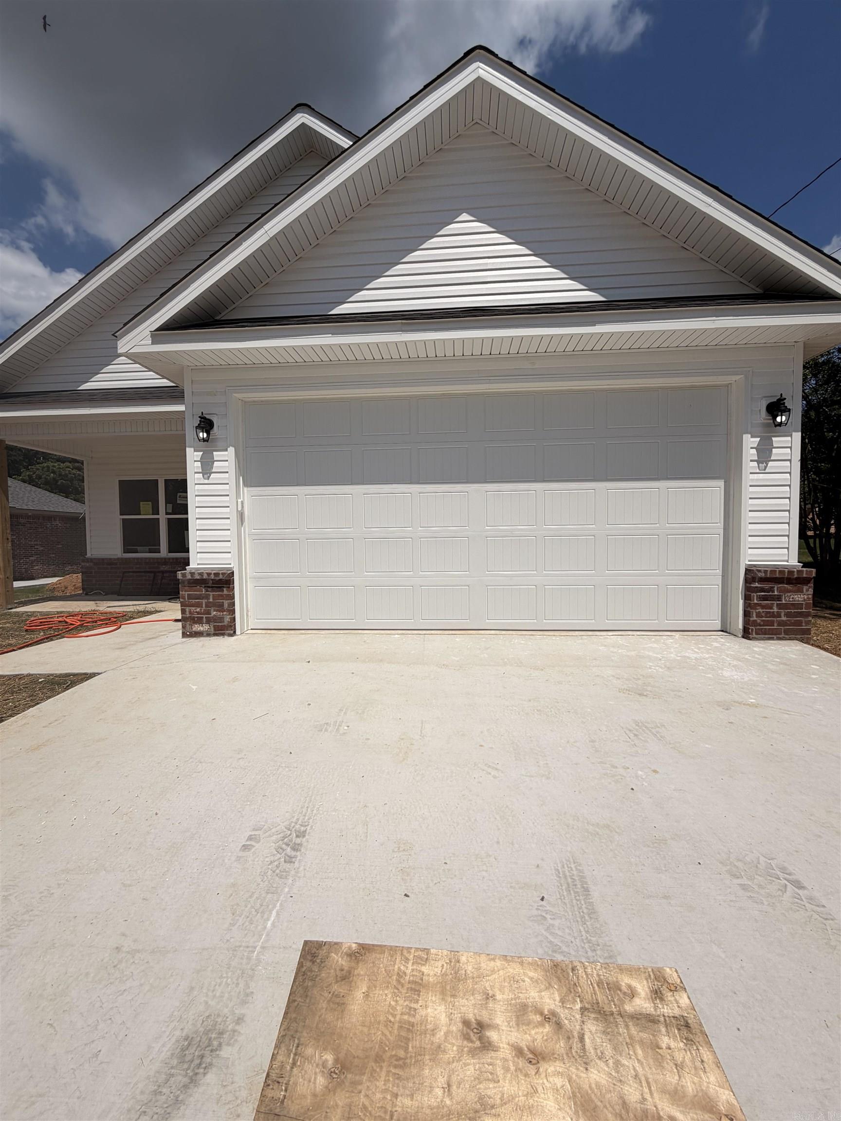 New brick & vinyl construction on a level lot! This 3BR/2BA, 1,253 sq ft home offers a vaulted ceiling in the kitchen and living area, large pantry, granite countertops, and custom cabinetry. Each bedroom features a walk-in closet, plus there’s a spacious laundry room and two-car garage. There is a large finished storage area over the garage. Built with spray foam insulation for efficiency and a wheelchair-accessible design for convenience. Includes a 1-year builder’s warranty—move-in ready!  Home is located a short commute to Hot Springs and Oaklawn Racing. 30 minutes from Benton, Bryant, Henderson State University, Ouachita Baptist University, DeGray Lake, and several State and National Parks. Less than a hour from downtown Little Rock with an easy commute!