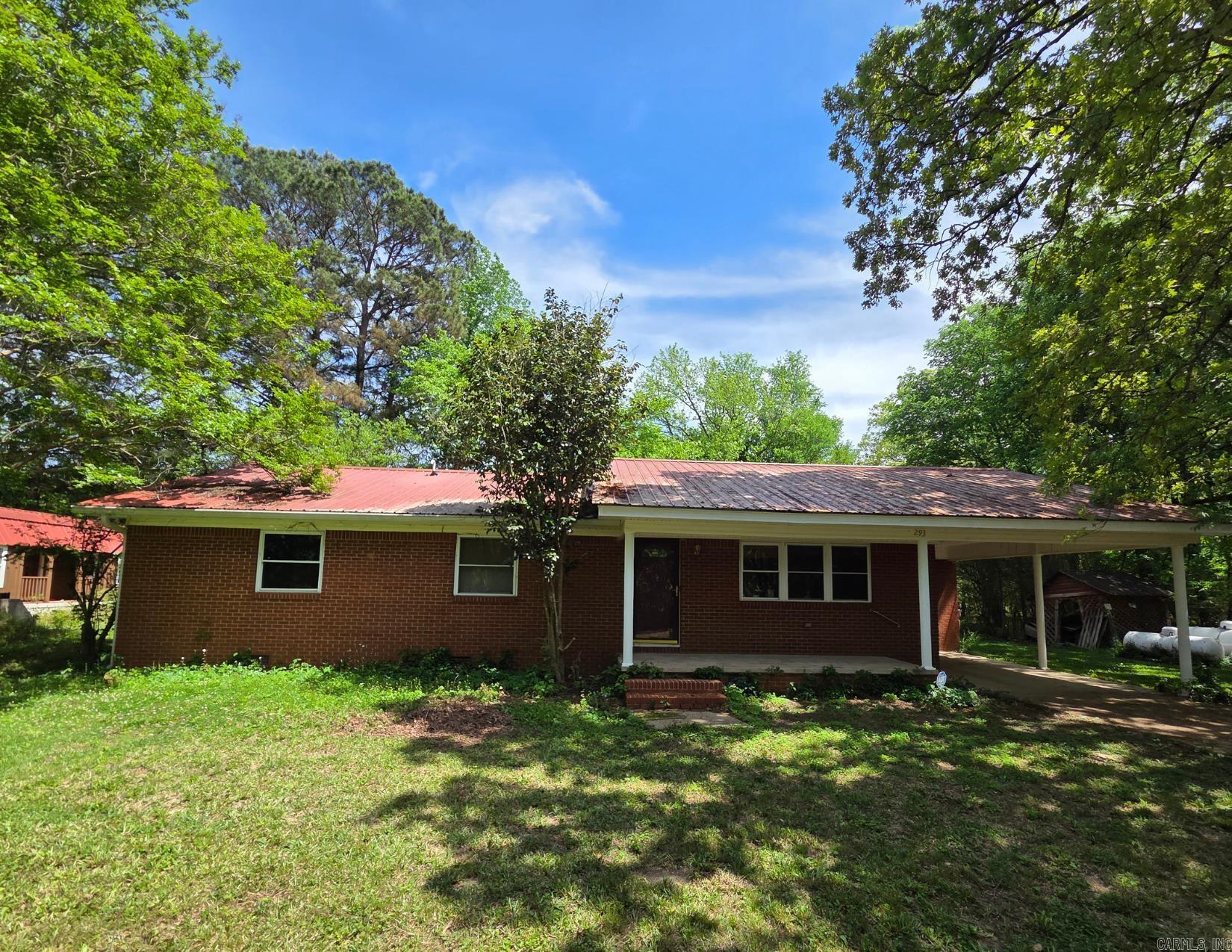 Enjoy oasis on over 10.5 acres in the Social Hill community & go fish in the spring-fed pond! This 1600+ square foot home features custom cabinetry and shelving throughout. Carpets have been removed to expose subfloors, which are in fine shape. Put your touch on it, and this 3-bedroom, 2-bathroom house could be your Forever Home. Metal roof is ~10 years old, with 40+ years of life left. All new insulated windows, updated plumbing, HWH 2019. Washer, dryer, refrigerator, and two part-full propane tanks convey. Two carports, a shop, a garage, underground storm shelter, and a craft cabin offer plenty of additional space for activities. Property is on public water, but also has a well. Once well pump is replaced, this place would be largely self-sustaining.