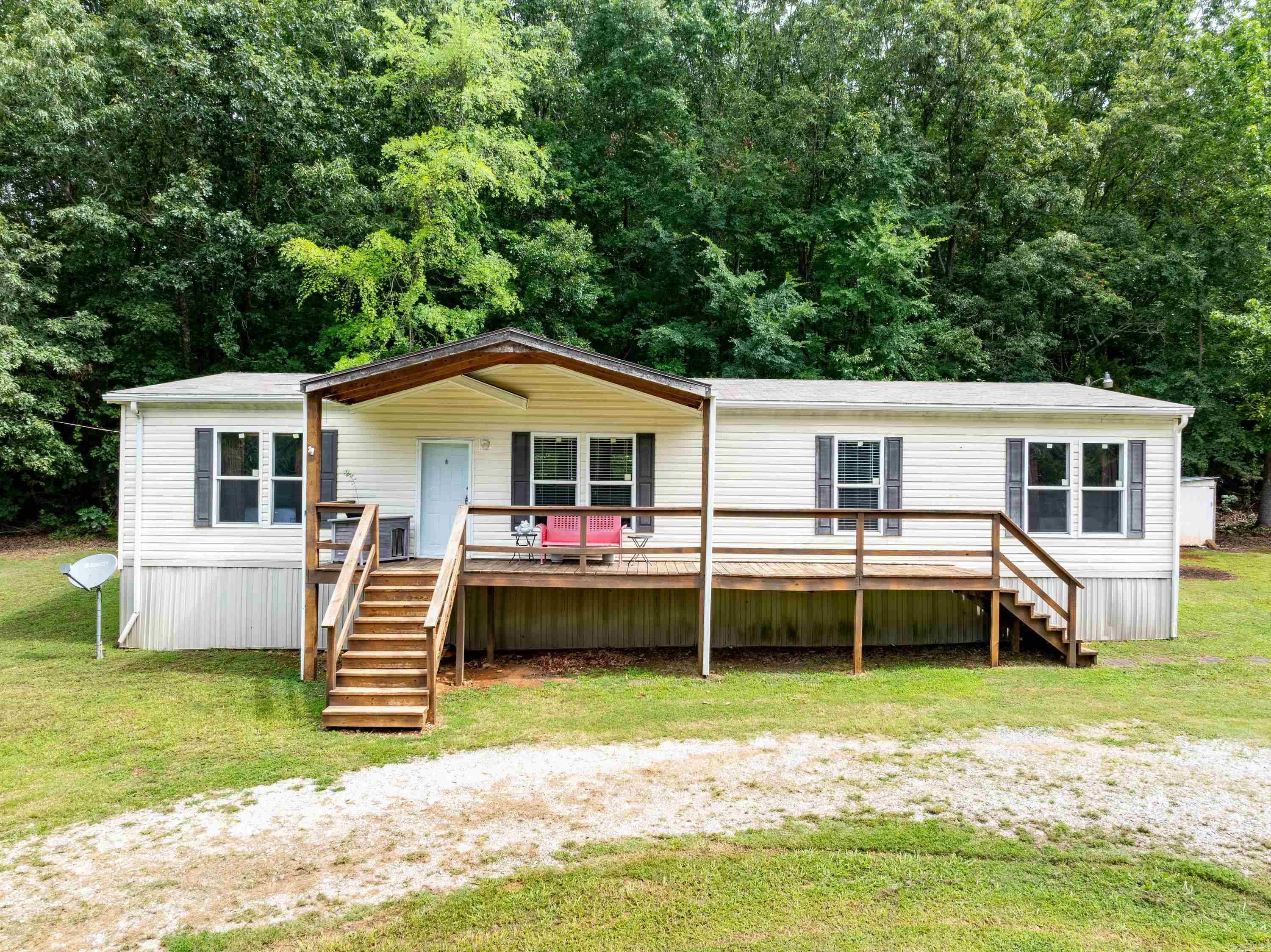 Immaculate one-owner 3-bedroom, 2-bath home on 1 acre in Independence County. This move-in ready property features a welcoming front porch, circular driveway, garden area, and mature trees providing shade and privacy. Inside, you'll find an open-concept floor plan with abundant natural light, built-in shelving, and a spacious living area that flows into the kitchen. The kitchen offers ample counter space, a beautiful farmhouse apron-front sink, electric range, refrigerator, bar seating, and plenty of storage. The dining area provides space for a large table, while the oversized laundry/mudroom includes a built-in bench, coat storage, and exterior access. The split-bedroom floor plan features two guest bedrooms and a full bath on one end of the home, with a private primary suite on the opposite end complete with a walk-in closet, double vanities, soaking tub, and separate walk-in shower. Located on Batesville Water, Entergy electric, and NCO internet. Situated on a paved road just approximately one mile off Highway 167 on Pfeiffer Road, offering the perfect combination of country living and convenience.
