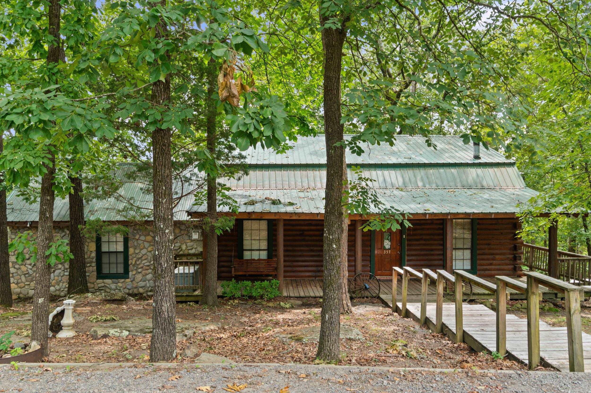 Experience the perfect blend of rustic charm and lakefront living in this log cabin on Greers Ferry Lake. Surrounded by towering trees and lake views, this inviting retreat offers the warmth of natural wood, a cozy cabin atmosphere, and the peaceful lifestyle you've been dreaming of.  Enjoy mornings on the spacious deck with coffee overlooking the lake and evenings gathered with family and friends after a day of boating, fishing, or swimming. Whether you're searching for a full-time residence or a weekend getaway, this property offers the ideal setting to relax and make lasting memories. Community area on the lake for picnics with a boat ramp. Don't miss your chance to own a slice of lakefront paradise on one of Arkansas's most beautiful lakes.