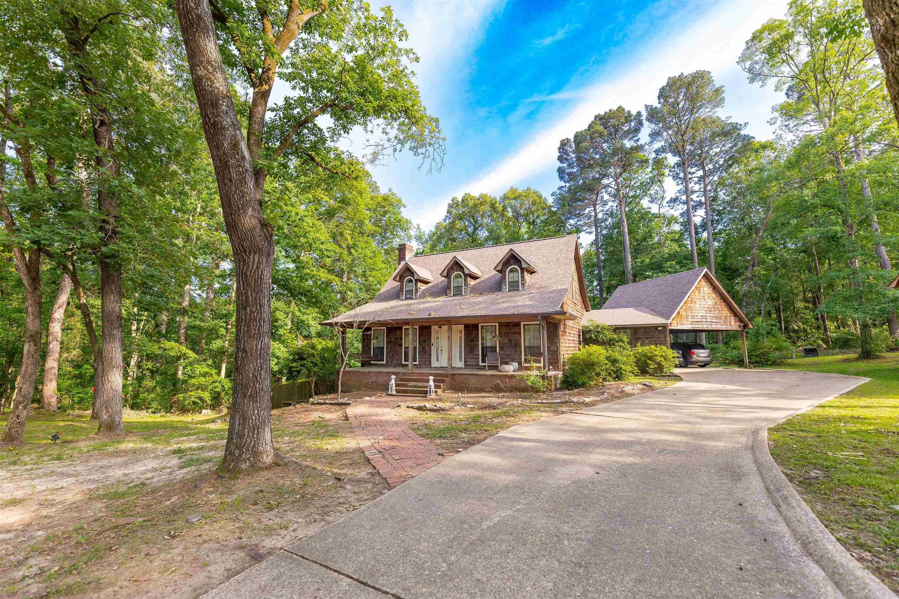 Charming wood-frame home with standout curb appeal and a large, welcoming front porch. Inside, a spacious living room anchored by a cozy wood-burning stove creates an instantly inviting feel. The vaulted den features dramatic ceiling-height windows that flood the space with natural light and provide seamless access to the back patio and privacy-fenced area of the yard. The open kitchen offers a vaulted ceiling, center island, and easy flow for everyday living and entertaining. The main-floor primary suite includes expansive closet space and a private ensuite bath. A half bath is thoughtfully located off the laundry area for guests. Upstairs, you’ll find additional bedrooms and a spacious full bathroom. The partially finished walk-out basement features 1,100 sq ft of storage or flexible space for hobbies, a gym, or future expansion. Situated on a rare 1.5-acre lot, the partially fenced backyard offers privacy and room to roam. Located at the quiet end of Cherokee Subdivision, this home provides a peaceful setting, personality inside and out, while still offering the ease of access to amenities and commute options.  New roof in Dec '25, fencing, flooring, and new WH in '24.