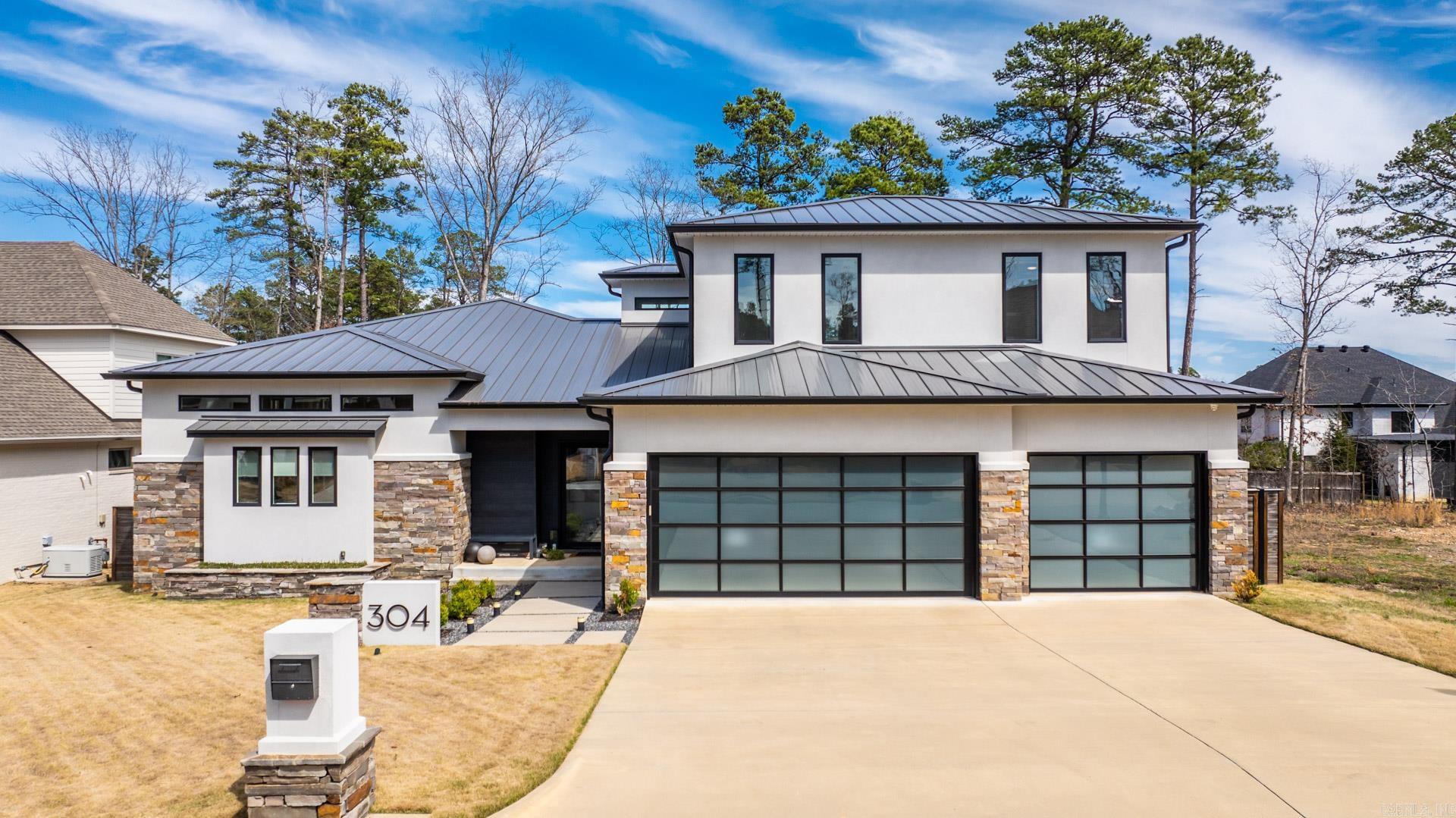 Experience luxury living at its finest in this stunning contemporary home in Chenal Valley’s coveted Ensbury neighborhood. This 4-bedroom, 4-bath residence offers a modern, low-maintenance lifestyle with exceptional amenities, including a heated saltwater pool, screened-in porch with built-in heaters, metal roof, and a 3-car garage wired for an electric vehicle charger. High-end finishes are showcased throughout: Thermador appliances, a wet bar with fridge and ice maker, porcelain flooring throughout, and a primary bath with keypad controls, free-standing tub with laminar filler, and spa-level details. Additional upgrades include a zoned HVAC system, dual tankless water heaters, sound system, HUE outdoor lighting, sprinkler system, fully fenced backyard, and  security system. Enjoy effortless access to Chenal Country Club by golf cart and the convenience of nearby shopping and restaurants. Don’t miss the opportunity to call this elegant, amenity-rich home your own Agents: See Docs for additional features and floor plan