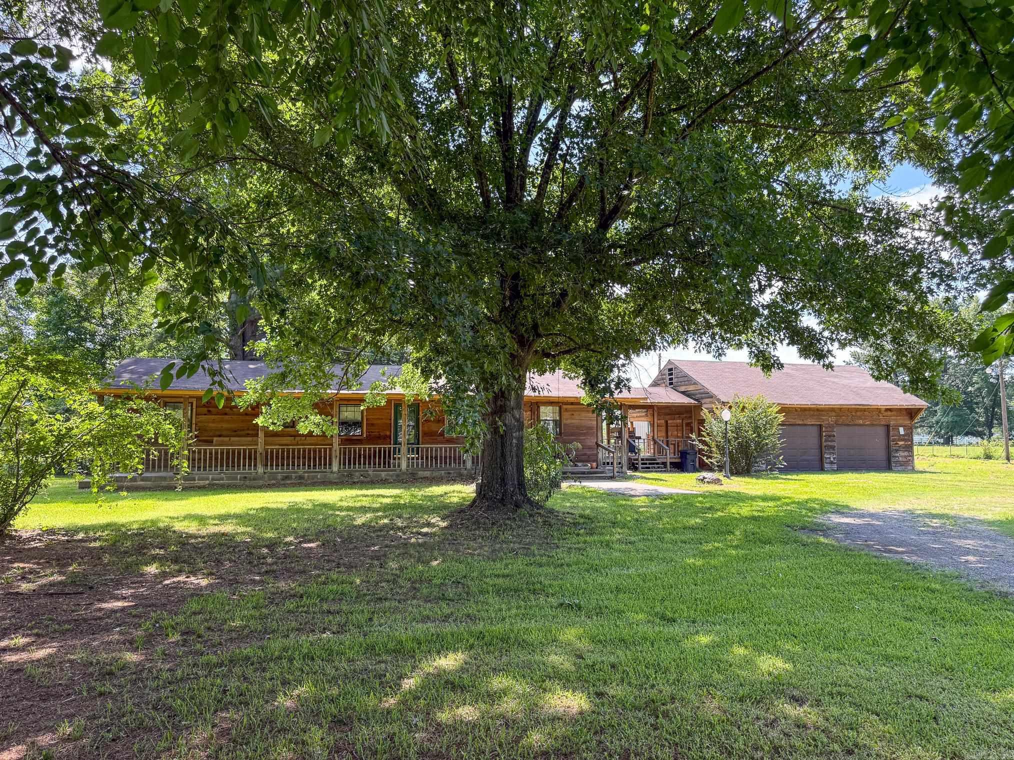 If you've been searching for a unique property with acreage, this log cabin style home is a must see! Situated on 6.14 acres, this 3 bedroom, 2 bathroom home offers rustic charm and the opportunity to enjoy country living. Gather around the cozy wood burning stove and enjoy the warmth and character that make this home truly special. The property features a detached 2 car garage with storage above, along with an additional outbuilding that includes a chicken coop, tack room, and rear storage. With plenty of space for animals, hobbies, gardening, or recreational use, this versatile property offers something for everyone.  Whether you're dreaming of a hobby farm, a place for your animals, or simply a home with room to roam, this rural property offers endless possibilities.