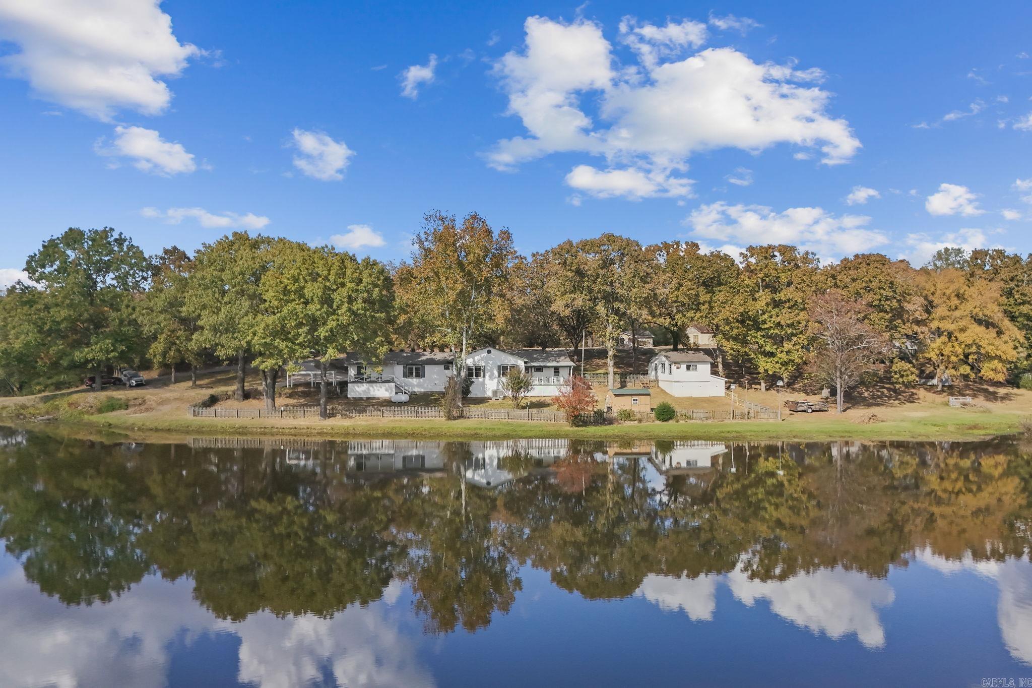 Discover the perfect blend of tranquility and convenience at this stunning lakefront property, uniquely set on multiple lots with expansive views of the water from nearly every window in the back of the home. Built in 1990, this spacious residence offers a rare layout that includes master bedrooms on each side, providing both privacy and comfort. Ideal for those who love both relaxation and functionality, the property features a beautiful sitting deck where you can unwind, enjoy serene lake views, or entertain guests against a stunning natural backdrop. One of the home's standout features is the large, versatile shop, perfect for hobbyists, additional storage, or creative projects. Imagine waking up each day to picturesque water views, sipping your coffee on the deck, and experiencing the peaceful ambiance that only lakefront living can offer. Whether you’re seeking a year-round home or a weekend retreat, this property promises a lifestyle of relaxation, beauty, and utility. With its thoughtful layout, abundant space, and breathtaking surroundings, don't miss the opportunity to make this lakeside haven your own. Schedule your personal showing today.