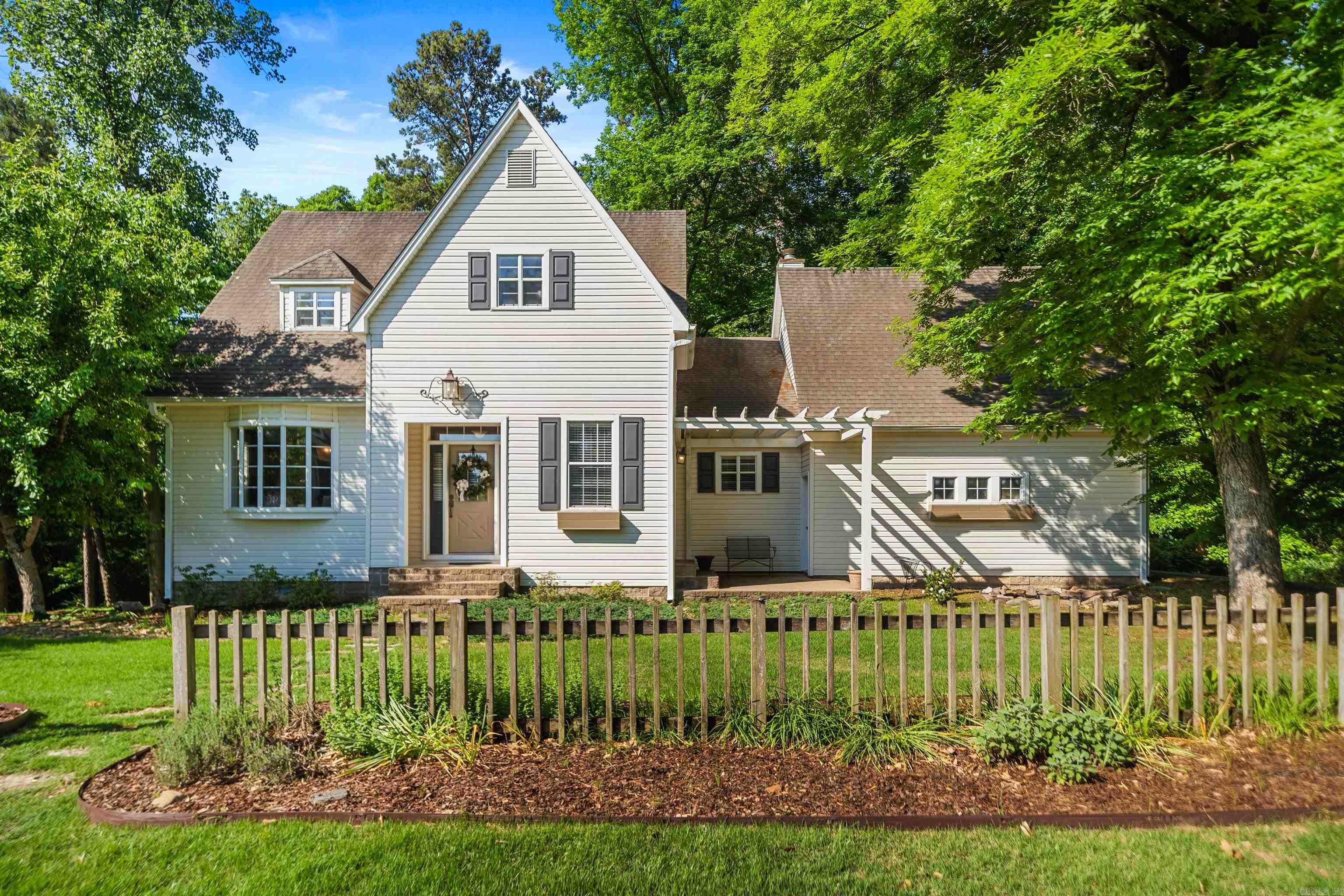 Elegant Craftsman-style home in desirable Timber Ridge Circle!  This beautifully maintained 4BR/2.5BA home offers approx. 2,062 sq ft and backs to a heavily wooded setting, creating a private, nature-inspired retreat with all the conveniences of city living in Arkadelphia.  Main level features 9’ ceilings, hardwood floors, crown molding, formal dining, eat-in kitchen with granite countertops, gas range, custom cabinetry, and French doors to patio/pergola area. Inviting living room offers a fireplace and triple French doors leading to an elevated deck overlooking peaceful woods and wildlife. Spacious main-level primary suite includes luxurious tiled walk-in shower and generous closet space. Upstairs features 3 additional bedrooms and full bath.  Enjoy a fenced backyard, wet-weather creek, and a private cleared area with concrete pad perfect for reading, meditation, quiet evenings, or camping with the kids. Bonus walk-out basement storage/workshop area.  Convenient to OBU, Henderson State, DeGray Lake, schools, shopping, dining, and I-30. Privacy, elegance, and lifestyle—all in one beautiful property!