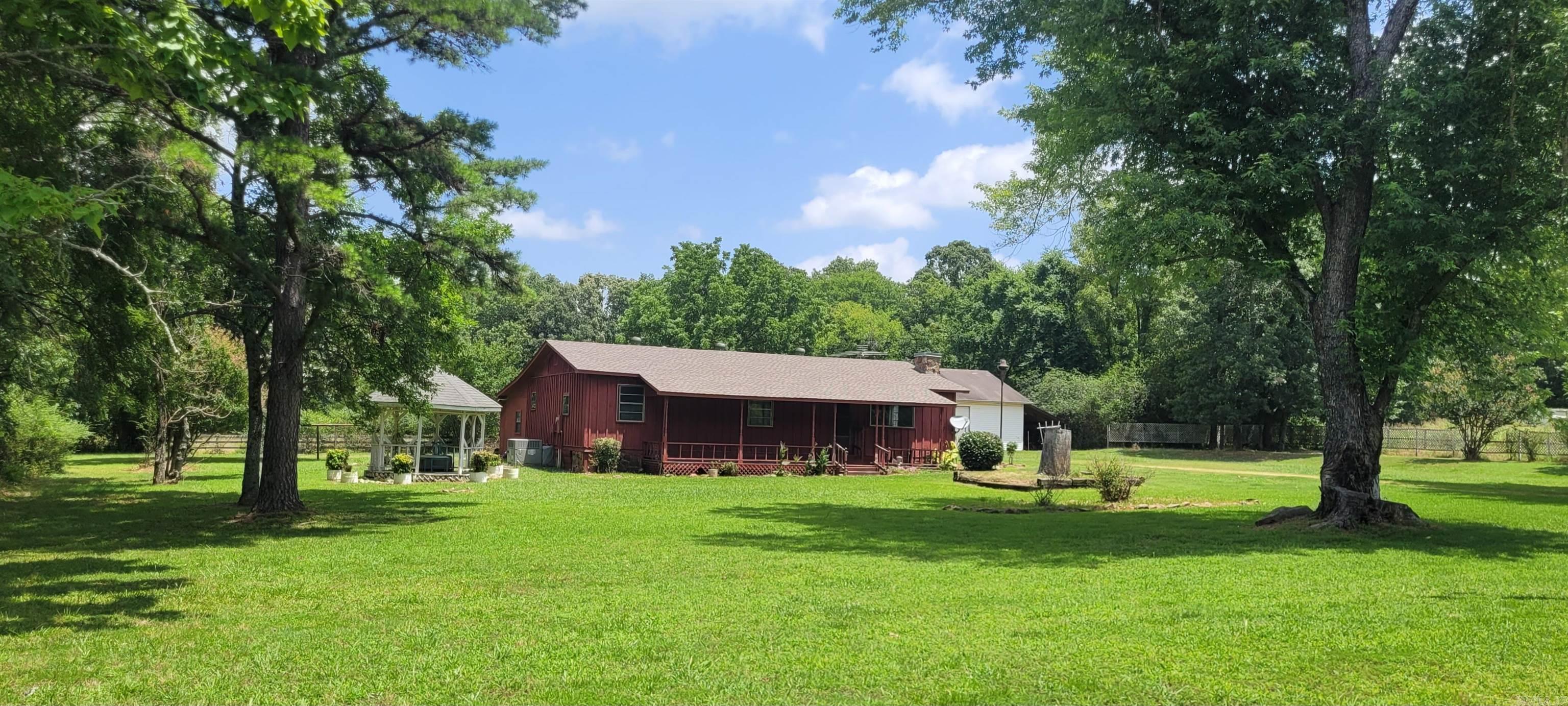 GORGEOUS SUNSET VIEWS from this 2 acre property with the possiblity to purchase 2 adjacent acres separately. A couple of additions to the single wide mobile home provide a living area with hardwood floors and front porch to enjoy the awesome sunsets, while the rear addition consists of a den with built-ins and a second full bath. The stackable washing machine and dryer unit is currently located in the main bathroom, but the laundry could easily be relocated to the enclosed storage off the hallway where hook-ups are already in place. In addition to the peaceful setting, a spacious shop, in-ground storm shelter, gazebo, and lots of lovely flowers round out the exterior features of this property. The roof on the home was replaced in January 2024 and the septic was cleaned less than 2 years ago. Just 12 mins to Riverside Park, 15 mins to Harding University, and 20 mins to Wal-Mart. *The wood-burning stove in the living room works, but the chimney can't be used. AGENTS SEE REMARKS