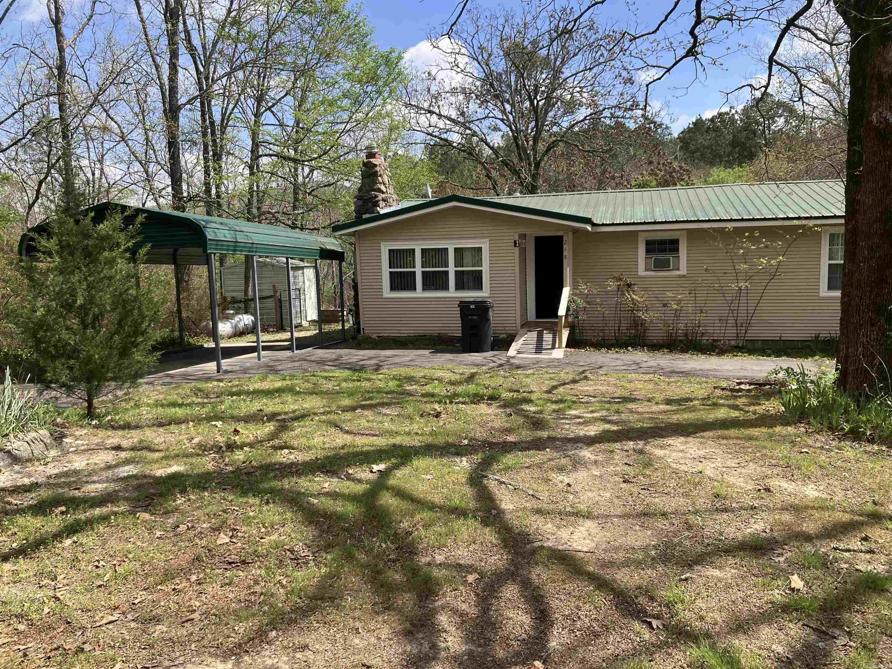 PRICE REDUCED! Country living minutes from downtown Hot Springs. This charming 2/1 Is located off Cedar Glades Rd. near Northwoods bike trails. The house sits on 1.1 acres. The backyard is not only fenced, but there is concrete around the bottom of the fence to keep dogs from digging out or in. It has a storage unit and a workshop in the backyard. There is a large deck and a covered back porch off the master bedroom. It’s a great place to enjoy your morning coffee or evening drink. There is also a total house generator which runs on propane for those times when electricity is unavailable. Two newer mini splits heat and cool the house as well. Two carports, one of them wide enough for two vehicles supply ample covered parking. The roof is metal for years of maintenance free living. Your insurance company will love that! The house features a large master bedroom with windows, adding a great amount of natural light. There is also a bonus room which was used as a third bedroom. All the windows are replacement windows and insulated. All the doors are insulated as well. The fireplace has an insert that heats most of the house in the winter. The microwave, refrigerator, washer, and dryer