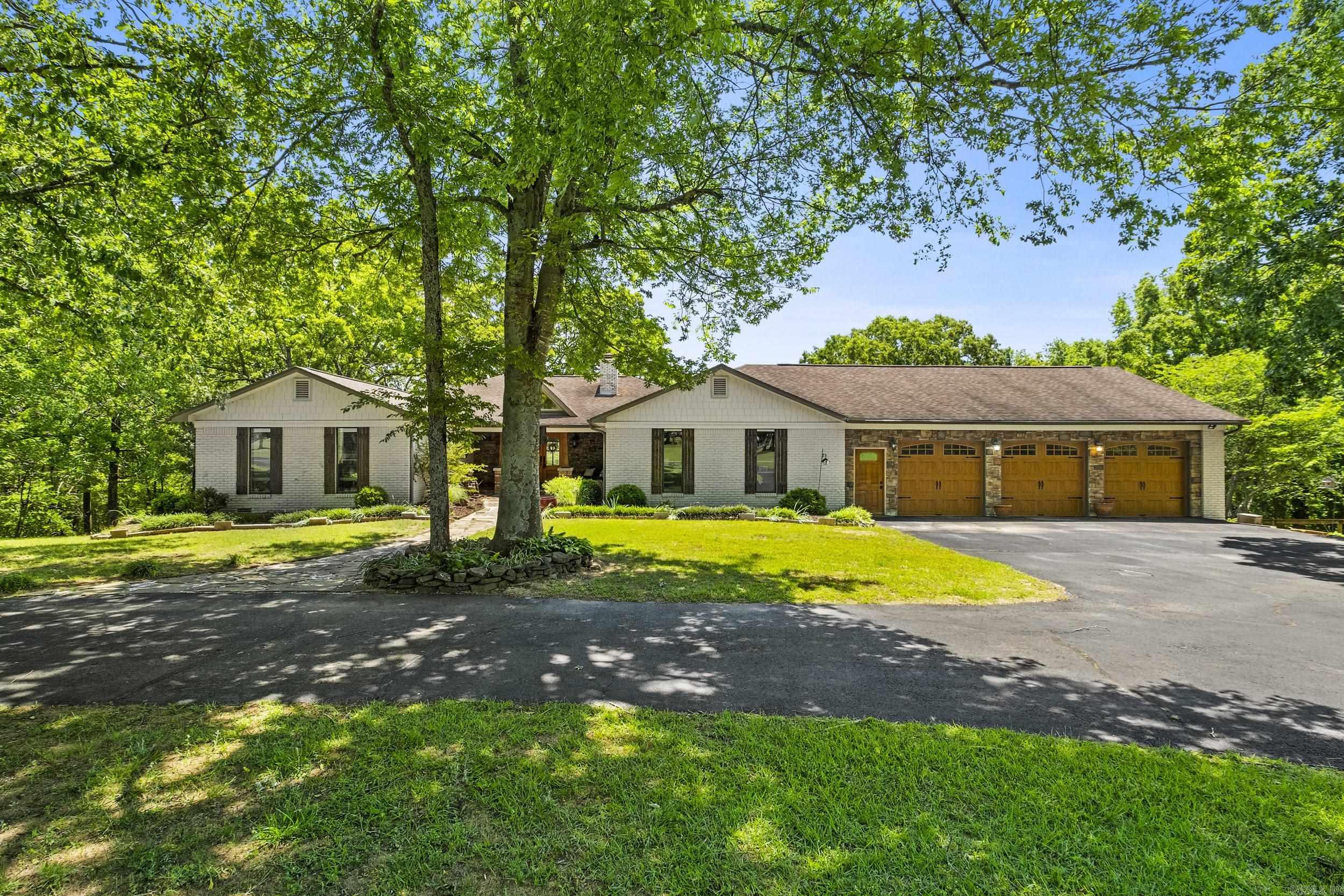 Sitting on 17 gorgeous acres just outside of Searcy, this spacious 5800+ sq ft custom estate offers a perfect balance of craftsmanship, privacy and comfort! This home features, a brand NEW roof, 5BRs w/ 2 of the guest rooms & a full bath on the main level with the updated primary suite which has faulted ceilings with a wooden beam, access to back deck, walk-in shower, updated vanities, lavatory, & huge walk-in closet. The basement has 2 guest rooms with a full bath between, great family room with stone fireplace, safe room, & large utility room for laundry, crafts & storage of all your things! The main level also boasts a lot of natural light, two living rooms, formal dining room, breakfast room & hearth room for cozy mornings by the fire! The kitchen features a double oven, 6-burner gas cooktop, quartz countertops & a breakfast bar. Spend hours outside on the amazing deck with gas fire pit, covered outdoor kitchen with gas grill, fireplace, & wood-fired pizza oven! Great home with endless entertaining and hosting potential both indoors and out! Don't forget the 3 car garage with a spacious storage room/shop that runs the length of it! Make this peaceful retreat your home today!