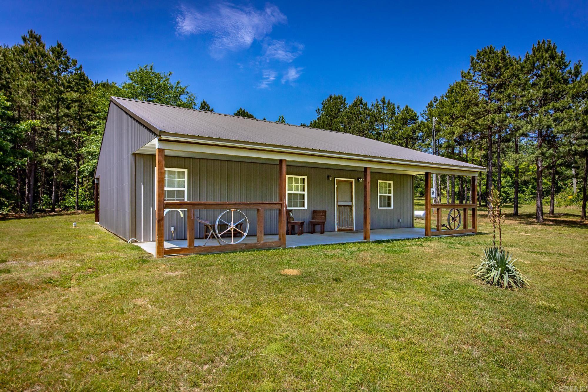 Well-built home built in 2018 with metal siding, metal roof, and covered front and back porches. Located just off a paved highway, this property offers easy access while still being tucked away from view. Inside features laminate flooring throughout and an open kitchen and living area with a comfortable layout for everyday living. The land offers plenty of room to enjoy the outdoors, and the property includes two outbuildings approximately 24x24 and 30x30. Both could easily be enclosed for large shop buildings, storage, workshop space, or covered parking. If you’ve been looking for a newer home with privacy, usable land, and room for hobbies or equipment, this property is worth a look!  This home qualifies for FHA, VA, Rural Development, and Conventional financing. See agent remarks before showing.