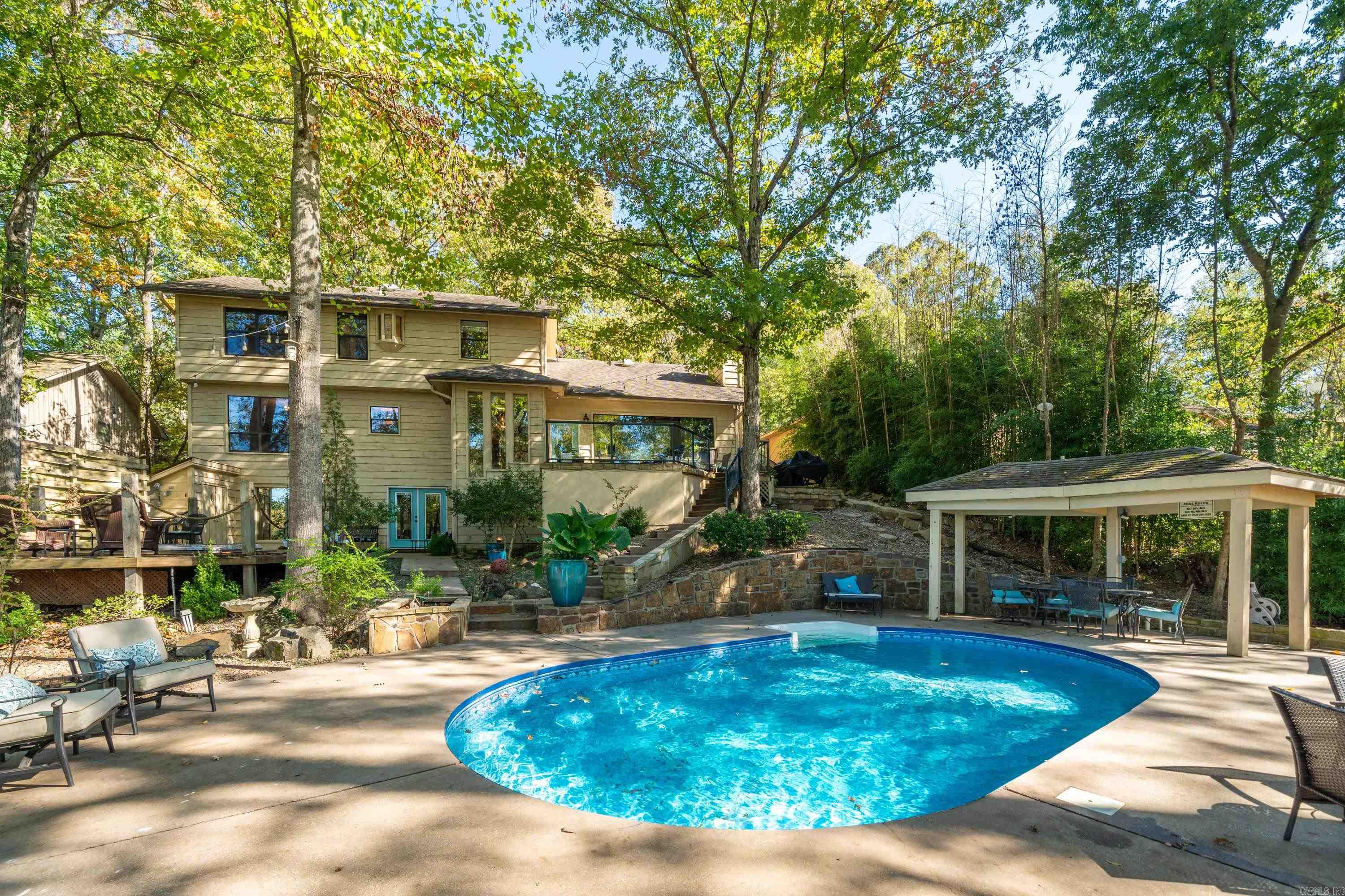 Welcome to Lake Hamilton living and experience the ultimate natural park environment in your own back yard! This property is perfectly situated with a relaxed, cozy setting on the lake.  It has a well-blended balance of privacy and expansive views of the lake. The rare find of green lawn stretching from poolside to water's edge, shaded with mature trees, showcase the natural beauty of Hot Springs National Park. Pool, hot tub, and sauna lends to an amazing entertainment setting! Inside the home, featuring multi-levels and separate living areas, the ease of relaxed lakelife continues. View this beautiful home well-suited for family or rental property. Double boat dock and swim platform.