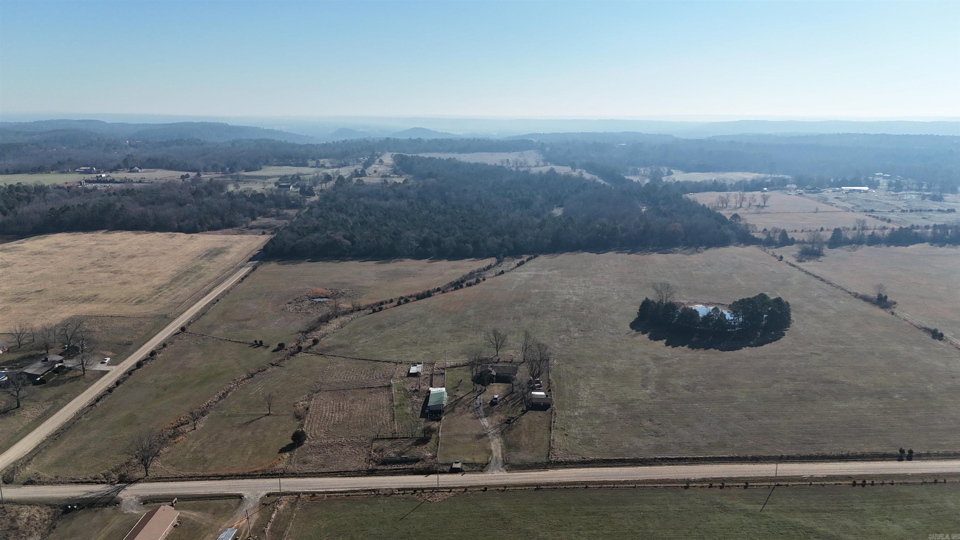 The property features open, well-maintained pasture, perimeter-fenced and cross-fenced into two large paddocks and two smaller paddocks. The acreage has been utilized for hay production over the last two years and is in excellent condition. Ample water for livestock is provided by a pond in each of the larger paddocks, along with a small creek. The eastern approximately 5+/- acres consist of thick cedar and hardwood timber, offering a suitable bedding area for deer.  A three-bay lean-to is available for storage, with a connected chicken coop and a fenced-in chicken run. Several mature Pecan trees are located within the fenced yard. Furthermore, a 330 square foot detached "Mancave" is present, featuring a fireplace and a stainless steel wet bar. It is ready for use as an entertainment space upon installation of a flat screen television.  The approximately 1500 square foot residence was constructed in 1961 and underwent a complete remodel in 2022. The home comprises three bedrooms and two full bathrooms, showcasing the considerable care and detail invested in the renovation. The exterior is finished with cedar siding on the front and sides, and vinyl siding on the rear. This property