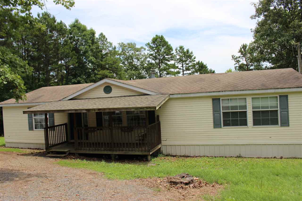 The most immaculate mobile home on the market! Features 3 bd, 2 ba, master is oversized. Open floor plan for kitchen/dining & living room has wood burning fireplace & is open to kitchen. Separate laundry room & pantry.  Refrigerator as well as the washer and dryer will remain. New updates include: new carpet throughout, new hot water heater, new paint, plus the addition on a new storage building. Other features include wood deck all along the back, 5.89 acres & gated.  Look today - won't last long!