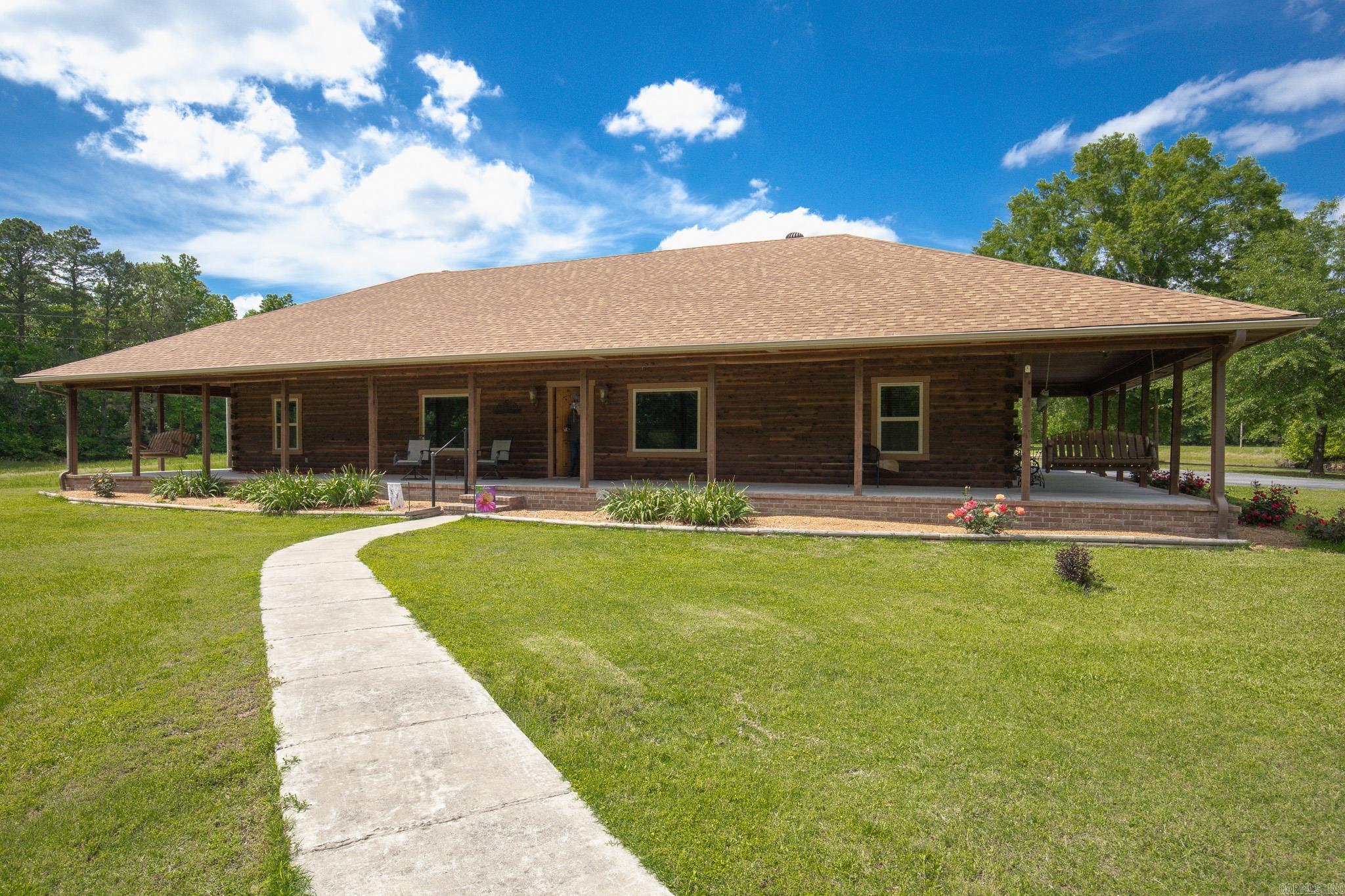 Escape to your own private retreat with this stunning custom log home nestled on nearly 37 beautiful acres! Built in 2018, this one-of-a-kind property perfectly blends rustic charm and country comfort. The home is approximately 2112 sq ft, 3 bedroom & 2.5 baths  and is loaded with unique charm throughout.  Gorgeous cypress beams and cedar accents all throughout, an inviting gas fireplace with a walnut mantle, and a warm semi-rustic design that feels both cozy and comfortable. The open kitchen features quartz countertops, a deep sink, electric cooktop, separate stove and a nice, spacious dining area. The oversized laundry room even includes a convenient half bath and safe room access. There’s also a spacious oversized garage. The primary suite offers a walk-through closet with custom walnut shelving along with a beautifully designed bath featuring a tile walk-in shower and double vanities. Such an authentic log home!  Outside you'll find a fenced 36.60 Acres with 50x30 ins. shop with 12' lean off & 146x100 covered arena. Enjoy peaceful mornings on the porch swing overlooking the fenced acreage, pond, and rolling landscape. Preapproval required to show. Roof 2023