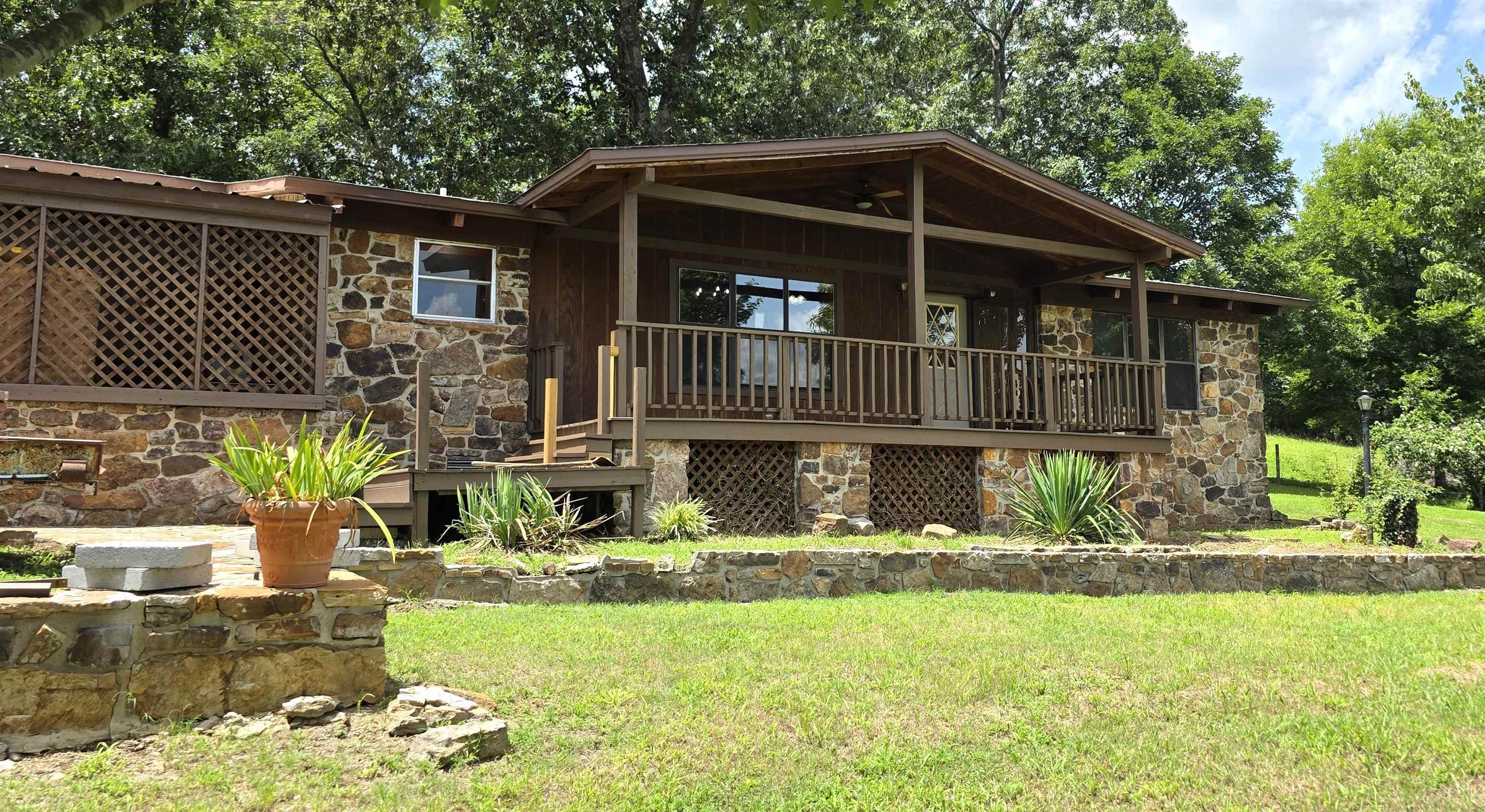 Enjoy to the peace and beauty of the Ozarks with this 2-bedroom, 2-bath home situated on 3.35 scenic acres.  Inside, you'll find a warm and inviting layout featuring beautiful wood flooring and a versatile bonus room that's perfect for a home office, guest space, game room, or additional living area. Step outside and enjoy the natural surroundings from spacious decks on two sides of the home, offering the ideal spots for morning coffee, entertaining, or simply relaxing while taking in the peaceful setting. A large 20' x 12' insulated shop provides excellent space for projects, storage, or a workshop. With plenty of room to roam and a location just a short drive from shopping, restaurants, city parks, live music on the courthouse square, the Ozark Folk Center, White River Health facilities, and the outdoor recreation opportunities of the Ozarks, this property offers the perfect balance of privacy and convenience.