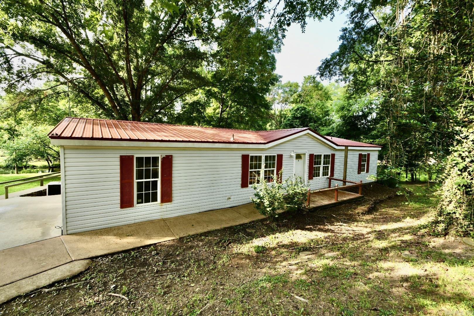 Lake Catherine opportunity with endless potential! Situated on approximately 0.60 acres in a peaceful, park-like setting, this 3-bedroom, 2-bath manufactured home offers the rare combination of privacy, lake access, and value. The property features a durable metal roof, solid permanent foundation, and sturdy floors throughout, providing a strong starting point for someone with the vision to complete and customize this unfinished project.  One of the standout features is the private one-stall covered boat dock on beautiful Lake Catherine, offering easy access to boating, fishing, and lakefront enjoyment. The adjoining community boat ramp creates additional open space next to the property, enhancing the sense of privacy and making the setting feel even more expansive without concerns about future neighboring construction.  Whether you’re looking for a full-time residence, weekend lake retreat, or investment property with lake access, this home offers tremendous upside potential. Tucked away in a secluded setting, yet just minutes from all the dining, shopping, entertainment, and attractions that Hot Springs has to offer.