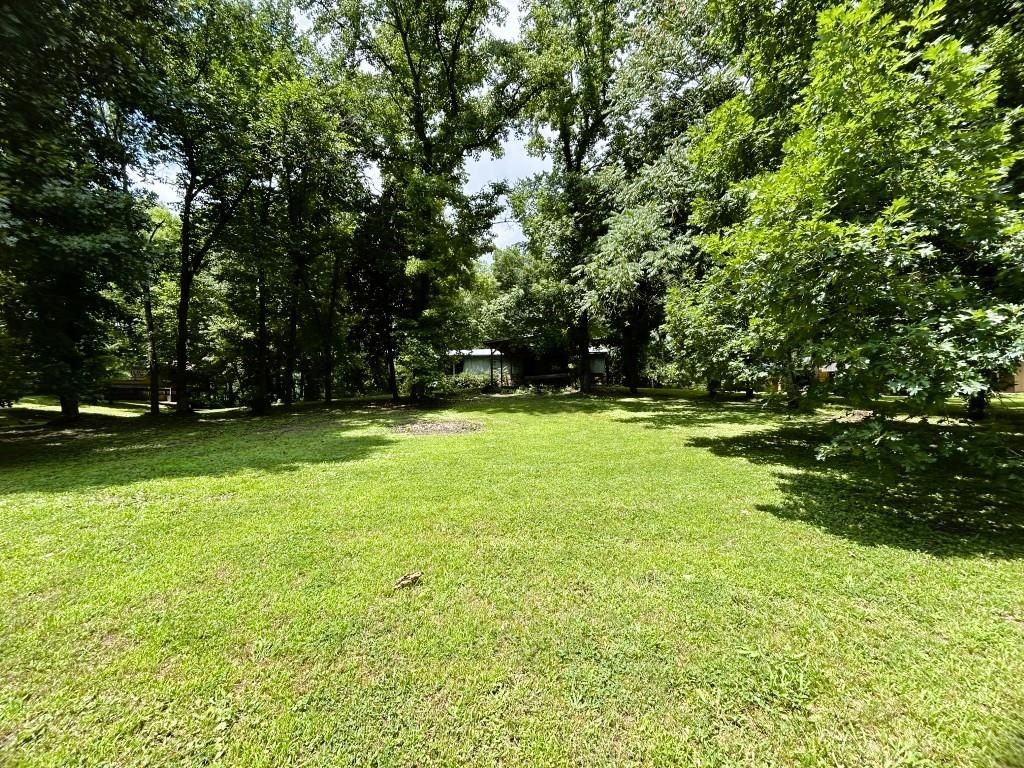 Looking for an affordable getaway on the legendary White River? This river lot offers the perfect opportunity to create your own fishing camp, vacation retreat, or weekend escape in one of Arkansas' premier trout fishing destinations. Known for outstanding Rainbow Trout fishing, the White River attracts anglers from across the country. An older mobile home sits on a basement and is ready for your vision and renovation ideas. With a little rehab, the mobile could become a comfortable base camp for fishing trips, family weekends, or a relaxing river retreat. The basement has experienced flooding in the past, but a creative renovation could transform the space into a covered outdoor living area, entertainment space, or storage area. The property is shaded by mature trees, creating a peaceful setting with plenty of privacy. With some selective clearing, you'll open up a wonderful view of the White River and enjoy the natural beauty this location has to offer. A two-car attached carport provides covered parking for vehicles, boats, or outdoor equipment. Existing septic, electric service, and water rights to a well are already in place.  $125,000