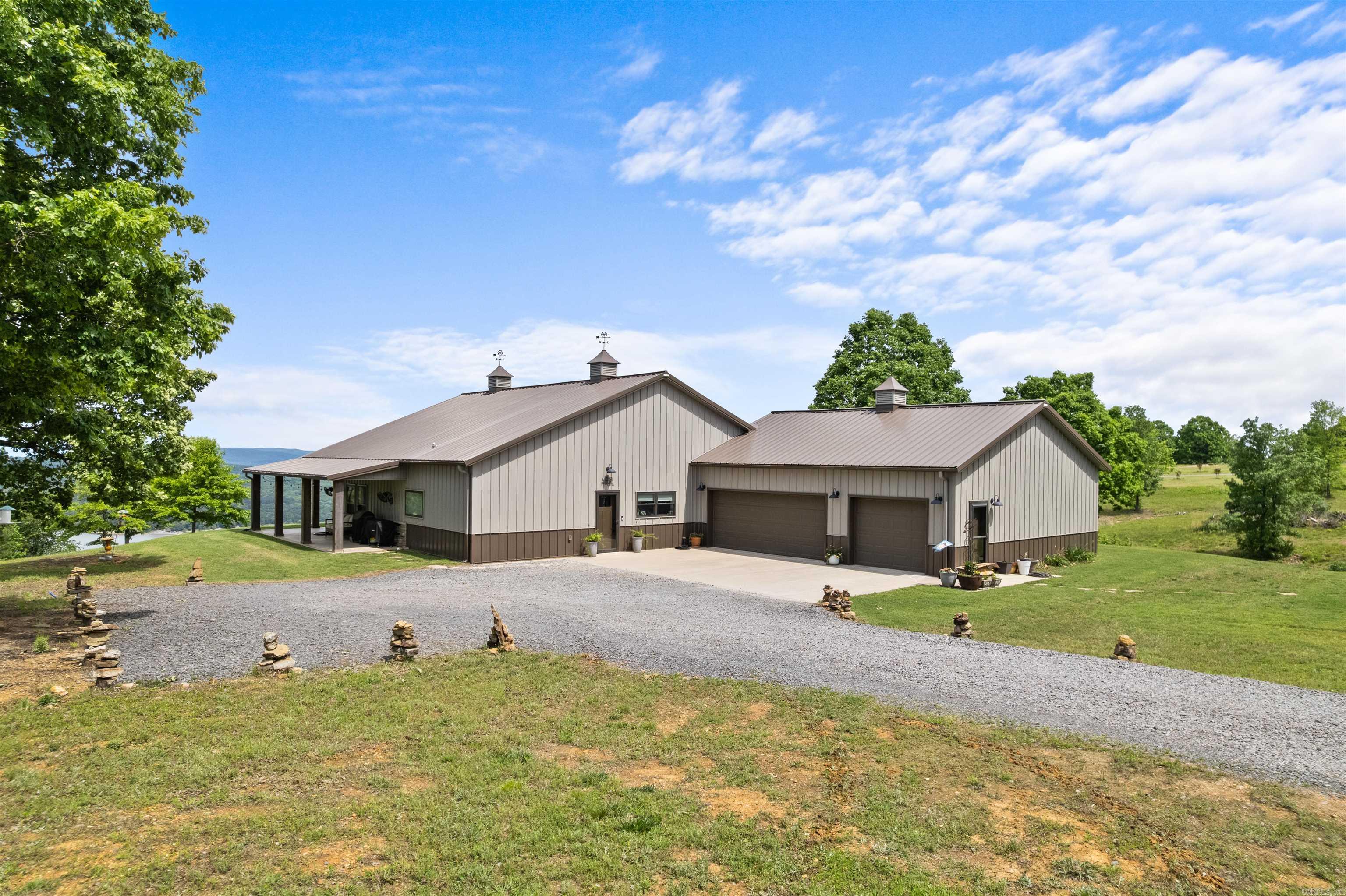 Experience Lake living at it's finest on beautiful Greers Ferry Lake with this stunning 3-Bedroom, 2-Bath Custom home that blends modern designed with rustic charm.  Inside you'll be captivated by soaring vaulted ceilings with exposed beams, creating a dramatic yet inviting open-concept living space. The designer kitchen is a true showstopper--featuring custom cabinetry, sleek countertops, high-end stainless appliances and more.  Natural light pours in, highlighting the home's clean lines and upscale finished throughout.  The living and dining areas flow seamlessly, offering both comfort and functionality, all while framing peaceful views of the surrounding landscape and lake beyond.  Step outside to a spacious covered porch adorned with string lighting--an ideal setting for relaxing evenings, hosting guests, or enjoying quiet mornings overlooking the lake.  A separate approximately 750 sq foot heated and cooled studio provides versatility--perfect for a guest suite, income producing rental, private office, or creative space.  15 min to Ferguson's Choctaw Marina 40 min to ATV Trails