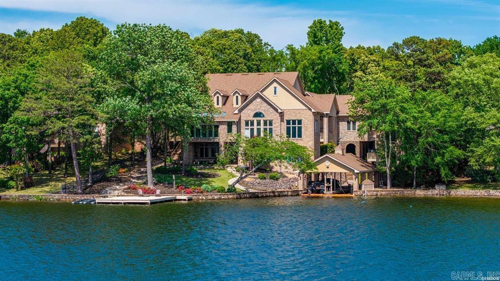 Experience the pinnacle of lakefront luxury in this stunning 6,360 sq ft estate, perfectly situated within an exclusive gated community. From the moment you step inside, you’re greeted by exquisite custom wood flooring and refined, high-end finishes that set the tone for the entire home. You have lake views from almost every room!  Designed for both everyday living and exceptional entertaining, the open-concept kitchen is a dream—featuring a large island, ice maker, spacious pantry, and a convenient built-in desk area. The formal dining room offers an elegant setting for hosting gatherings or having your evening meal with family. The sunroom will take your breath away offering a unique wall of accordion windows—creates a seamless indoor-outdoor experience and filling the space with natural light.  The main level also boasts a formal living area, versatile family/game room complete with theater seating and a game table. The expansive primary suite is a true retreat, offering a private balcony overlooking the estate, an oversized walk-in closet, and a luxurious ensuite bath with a dual vanity, water closet, and a premium soaking tub.