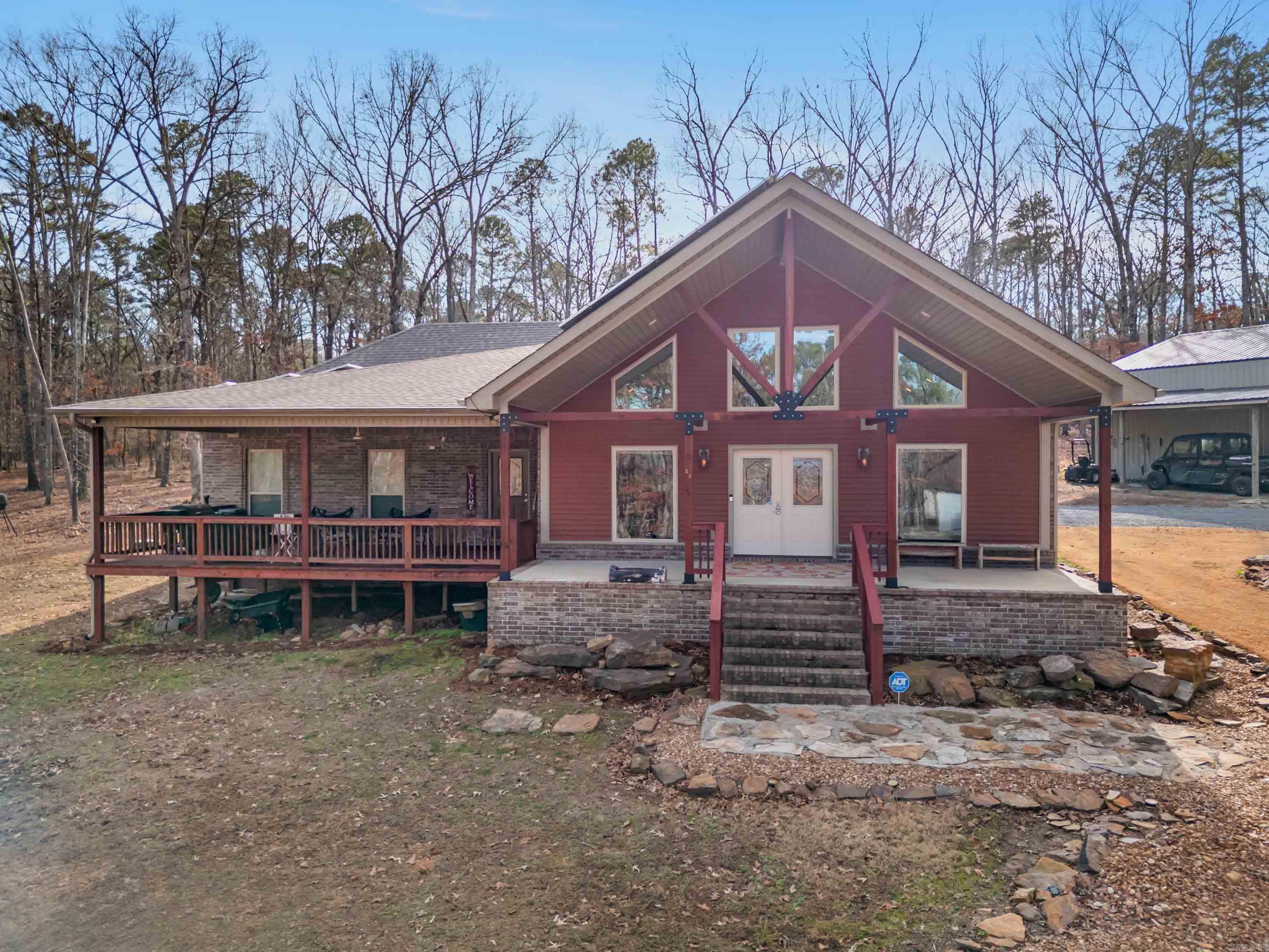 MOTIVATED SELLER!!!  Enjoy the best of lake living just steps away from GREERS FERRY LAKE! This home is FURNISHED  & offers the perfect blend of comfort, space, & outdoor recreation. Step inside to a spacious great room featuring a vaulted ceiling & cozy fireplace with gas logs—ideal for gathering w/ family & friends after a day on the water. The open feel continues outdoors w/both a covered deck & an expansive front deck, where you can relax & take in the peaceful surroundings, including a view of the lake right from your front porch. Situated on 2.8 acres, this property provides plenty of room to spread out, along with a large shop that’s perfect for storing boats, lake toys, or creating your dream workspace. With a launch area just steps from the home, getting on the water couldn’t be easier. Located in a community that features a beautiful golf course & a convenient airstrip, this property offers a unique lifestyle perfect for those who love to golf, fly, boat, & enjoy the outdoor. Whether you’re looking for a full-time residence, weekend retreat, or investment opportunity, this property delivers the space, location, & amenities that lake living truly exceptional!