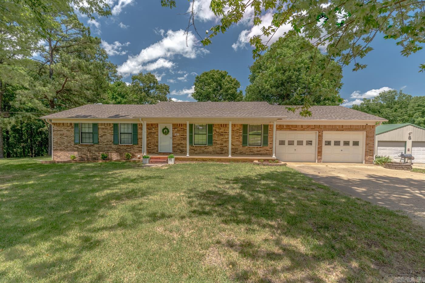 Country acreage, a shop for your projects, and a place to call home—some might call that countryside bliss! Situated on approximately 4.26 +/- acres near Lake Frierson, this brick home offers 1,736 square feet on the main level plus an additional 812 square feet in the basement. Step inside to a spacious living room with a semi-open floor plan and enjoy the updated flooring that extends throughout the living room and bedrooms. The dining area features French doors leading to the upper deck overlooking the backyard and above-ground pool. With a covered section on the deck, you'll have the perfect space for relaxing or entertaining! The basement features a versatile flex room and storage space with both interior and exterior access. This property offers a 30 x 40 shop with 220 amp electricity and two garage doors. Don't just dream about country living, call today to take a tour!