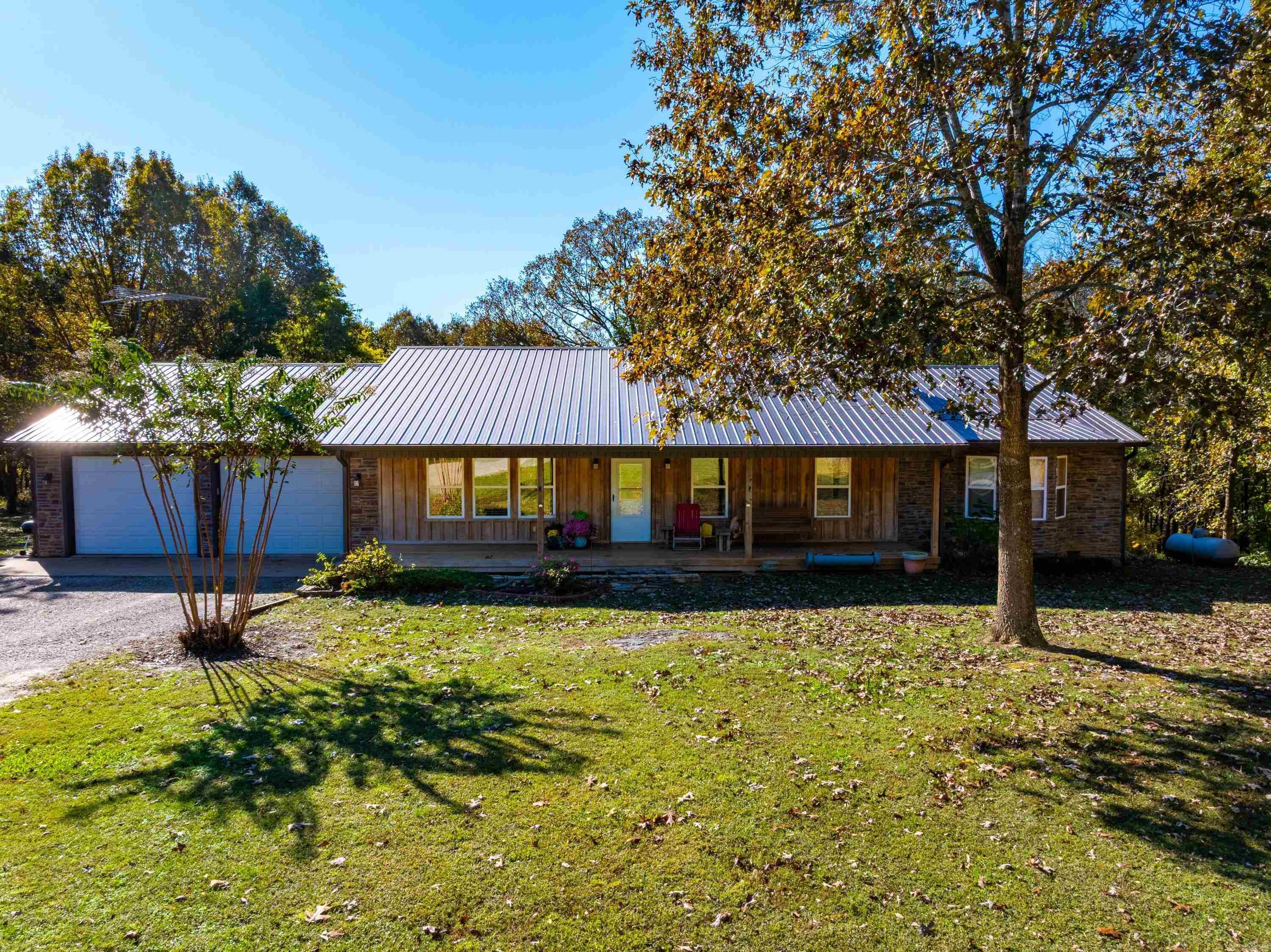 This exceptional Ozark property offers approximately 110 acres across Sharp and Izard Counties with 3,900+ feet of Piney Creek frontage, abundant water, and a beautifully maintained landscape. Built in 2013, the custom home sits on a gentle hilltop with scenic views of rolling land and timber. The home features over 5,200 sq ft under roof (approx. 3,534 heated and cooled), including vaulted pine ceilings, cedar accents, and custom wood flooring. The open living and dining area flows to a covered back deck overlooking the property. The kitchen includes knotty alder cabinetry, granite countertops, an island with vegetable sink, and quality appliances. The primary suite offers four closets, double sinks, jetted tub, laundry area, and private balcony access. Two additional bedrooms and a full bath are on the main level. The finished basement provides a second living area, guest bedroom, full bath, hobby room, secure storage, and additional laundry. Utilities include central propane HVAC, outdoor wood furnace integration, backup heat sources, owned propane tank, generator-ready panel, and a French drain system. The land includes two ponds, a seasonal creek, and more!