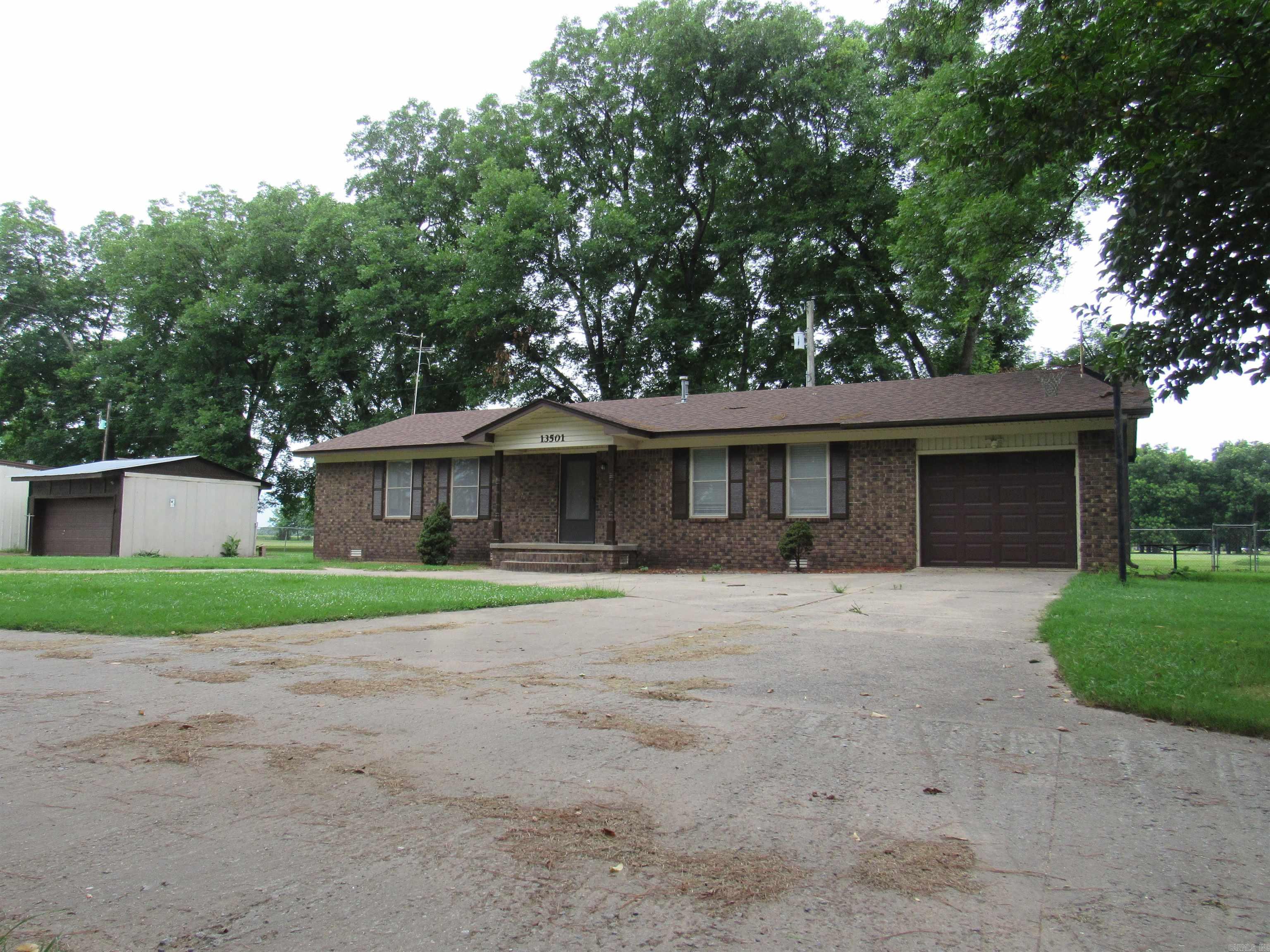 Super cute and meticulously maintained 3BR/2BA brick home near Old River in Scott! Inside features a welcoming living room, dedicated dining area, and a kitchen equipped with a stove and dishwasher. The master suite boasts convenient "his & hers" double closets, and there is a spacious laundry room with great cabinet storage. Attached is an oversized 1-car garage with a beautiful, clean epoxy-finished floor.  The exterior setup is an absolute dream for hobbies and storage! It features a massive, detached 2-car shop fully equipped with HVAC (heating/cooling), electric, water, a half bath, and a built-in basement for extra storage and the ultimate peace of mind as a secure storm shelter. Additionally, there is a second detached garage/work space with electricity and pegboards, a large 3-car carport perfect for boats or extra vehicles, and a storage shed with a loft that’s perfect for extra gear or a kids' play space. All this sits on a beautiful, expansive yard with tons of room to play. Don't miss out on this rare find—call today!