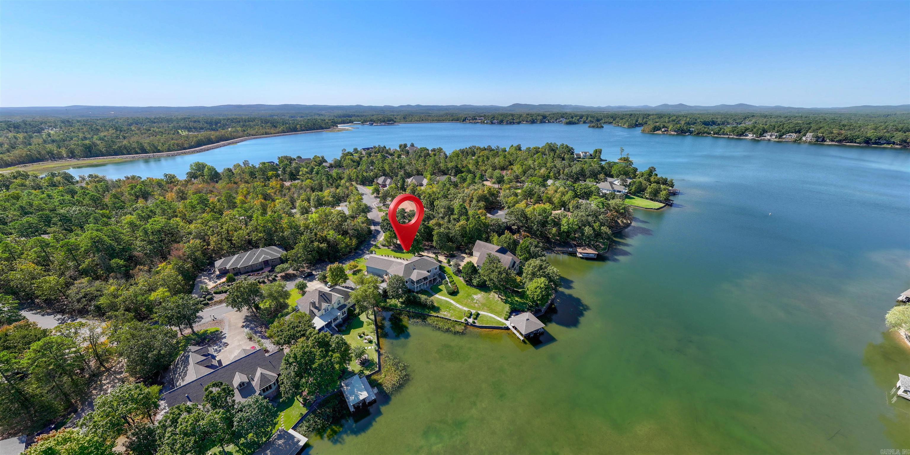 RARE FIND! 4 Car Garage and 233' of Gorgeous Lake Balboa WATERFRONT with a Double Covered Dock with Lift!!! Newer Luxury LVP Flooring greets you upon entry to this Cooper built home. Double doors open to the Oversized Den with built-ins, and the Living Room with Tray Ceiling looks out onto the Panoramic Water View! This beautiful home boasts 4 Bedrooms and a Den with Built-ins, Custom Maple Cabinets in the Quartz Island Kitchen and Eating Area! The Primary Suite overlooks the Lake, and an Ensuite offers His/Her Vanities, Jetted Corner Tub, and Walk-in Closet. The Covered Upper Deck offers amazing views of the Gorgeous Backyard and Lake! The Lower Level is perfect for Entertaining or Guests, with a Wet Bar/Mini Kitchen, 2 Bedrooms, a Full Bath and a Huge Storage Area that could also be a Workshop/Hobby Room! The "Dream Garage" boasts 4 Bays, has Storage Cabinets as well as a Shop Area! 26,000 acre Hot Springs Village boasts 11 Lakes & 9 Golf Courses, Tennis, Pickleball, Fitness Center, Indoor & Outdoor Pools, Miniature Golf, Archery Range, Bocce Ball, Dog Park, 20 Miles of Walking Trails, 24 Churches, Restaurants, Performance Center, and much more!