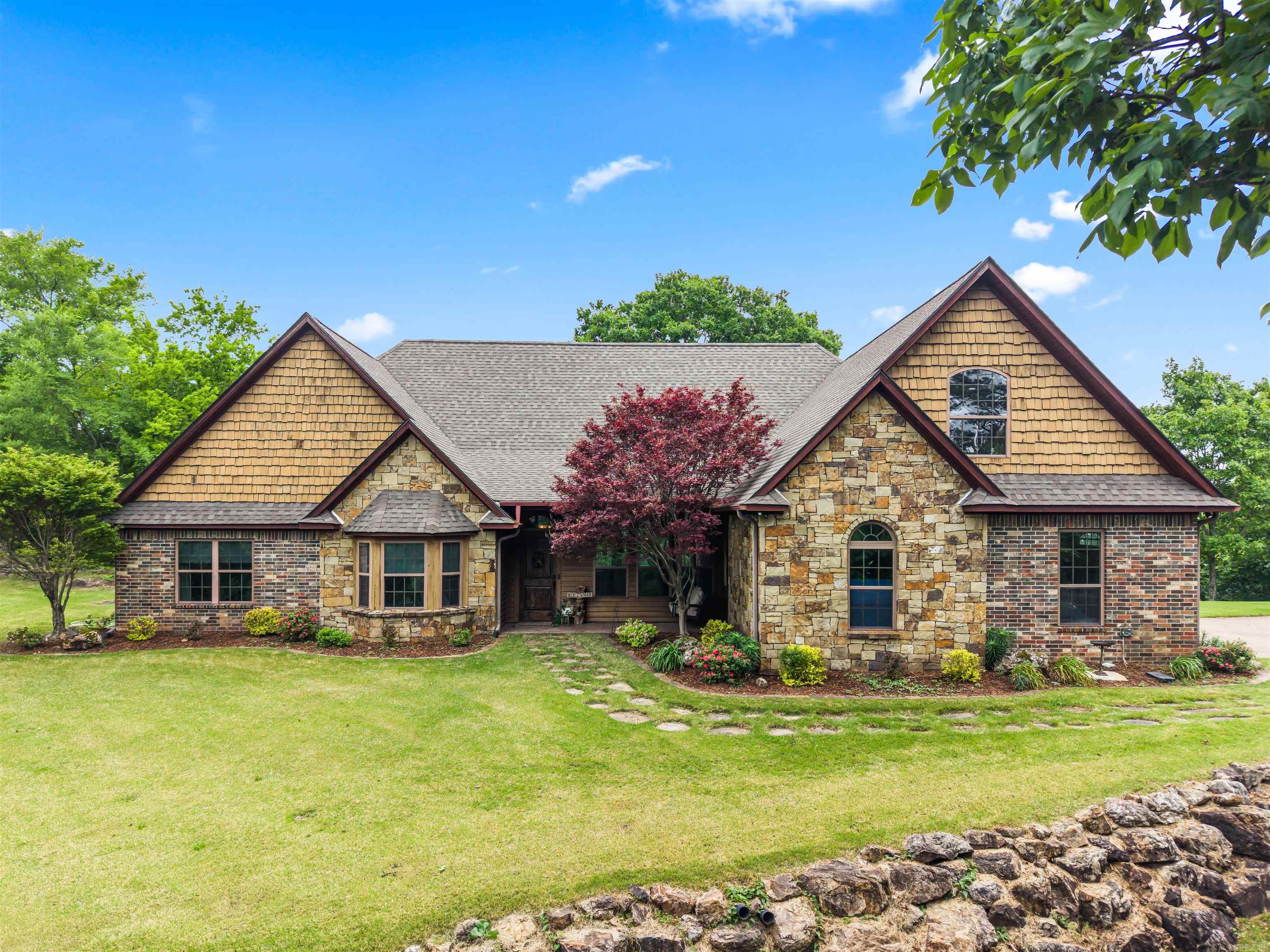 Breathtaking mountaintop retreat with world class 360 views situated just minutes from downtown Mena. Private, elegant, and immersed in nature, this incredible property truly has it all! The living space features floor to ceiling panoramic windows, a wood burning fireplace, and vaulted ceilings. The kitchen boasts granite countertops, Travertine floors & backsplash, a brand new stainless steel stove & dishwasher, and a large pantry. The spacious primary suite bathroom features a jacuzzi tub with VIEWS, double shower heads & sinks, and heated floors! The additional 2 downstairs bedrooms each have their own walk in closets, and one comes with a gorgeous built in bunk bed! The guest bathroom doubles as a storm safe room. Upstairs there is a bonus room, a 4th bedroom and bathroom, ideal for a guest suite or teen room! Oversized garage with plenty of storage space! There is also a tranquil fountain nestled in the natural rock formation next to the house, and a Hot Tub! Recent updates and additional features  include a new roof, carpet, interior and cabinetry paint. Whole house generator, built in floor & car vacuum systems, outdoor sprinkler system, and built in sound system.