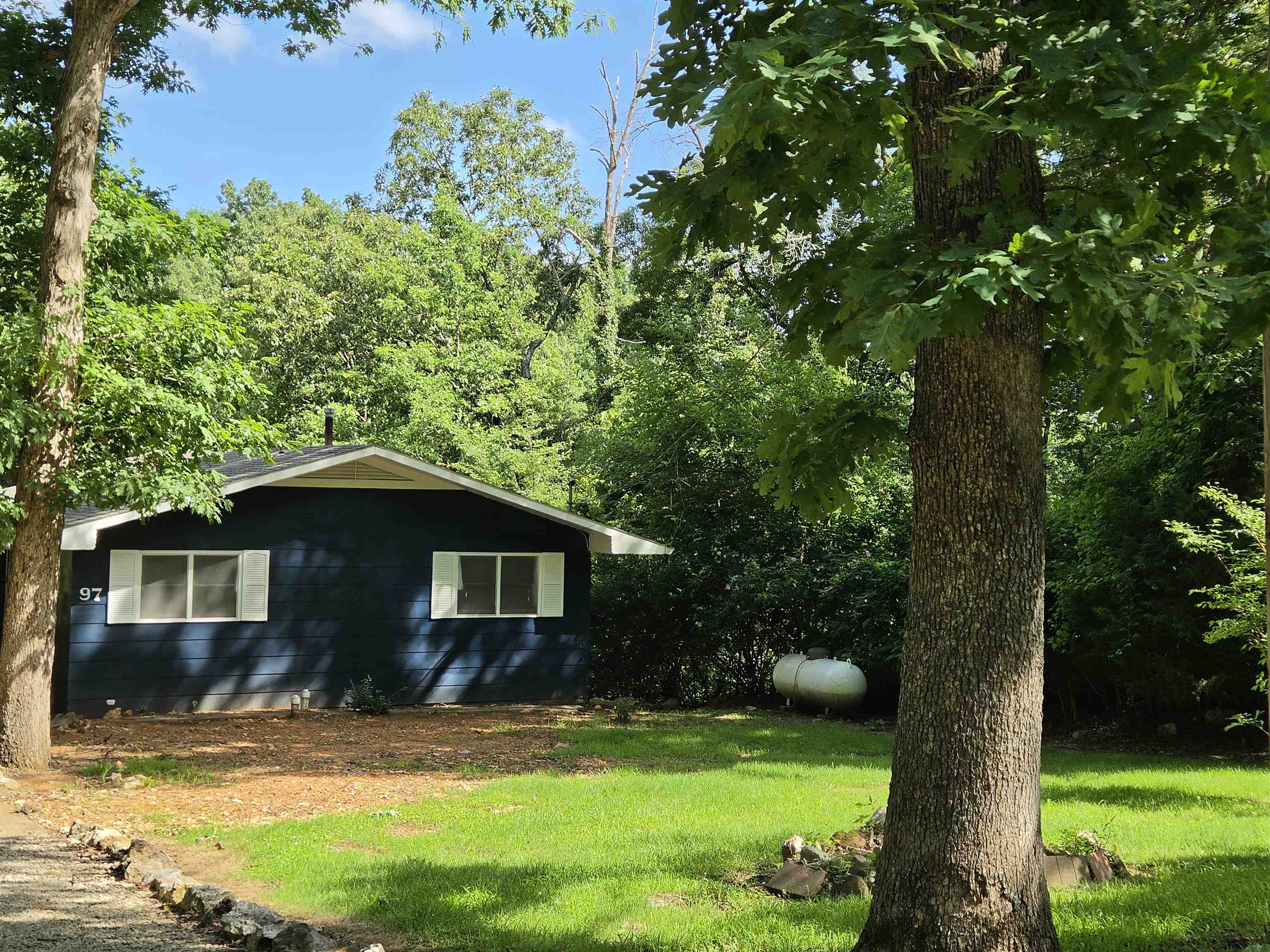 Lake Vagabond home with wraparound deck and patio. Privacy appreciated with no home on either lot beside or across the lake. Updates include roof 2024, vinyl plank flooring on the upper level, bathroom remodel changing over to large walk in shower, Interior and exterior paint. Custom wood door and window framing. Main level included large primary bedroom and 2nd bedroom. Bathroom can be accessed from primary or from the hall. Kitchen is open to the living area with custom built island with butcher block top and seating spots. Fridge, dishwasher, stove, washer, dryer and 2nd fridge all stay. Walk-in pantry for extra storage. Fireplace on each level for back up to central heat/air. Sliding glass doors to composite deck from dining and living areas for low maintenance. Lower level has another bedroom, family room and easy access to furnace/water heater. Kitchenette with sink, cabinets and fridge in laundry room plus more room to place your freezer or even put in a stove. Sliding glass doors in family room and bedroom lead to covered patio and short walk down to the dock. Carport and shed for more storage. Come enjoy country living on the lake, w/little light or noise pollution.