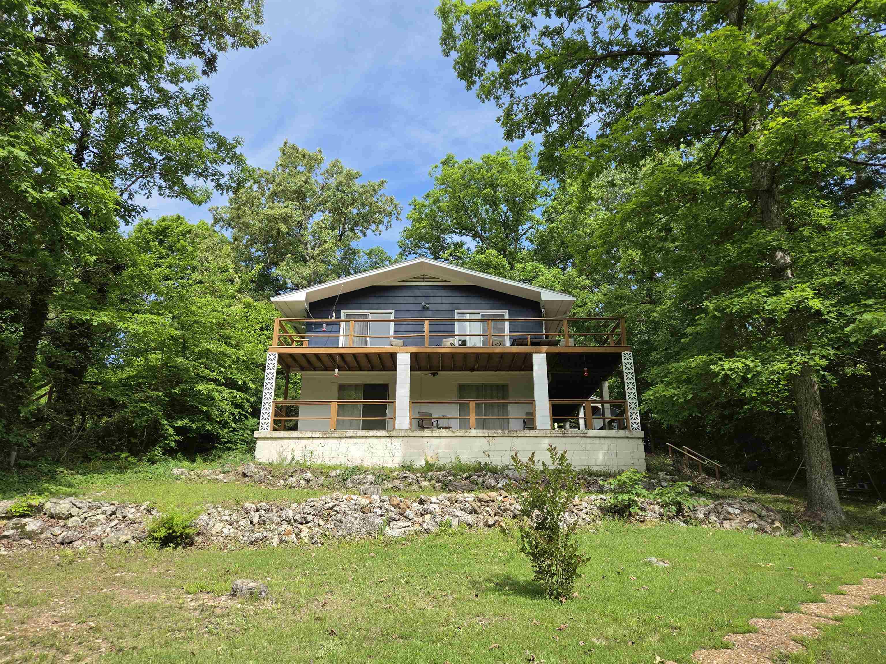 Lake Vagabond home with wraparound deck and patio. Privacy appreciated with no home on either lot beside or across the lake. Updates include roof 2024, vinyl plank flooring on the upper level, bathroom remodel changing over to large walk in shower, Interior and exterior paint. Custom wood door and window framing. Main level included large primary bedroom and 2nd bedroom. Bathroom can be accessed from primary or from the hall. Kitchen is open to the living area with custom built island with butcher block top and seating spots. Fridge, dishwasher, stove, washer, dryer and 2nd fridge all stay. Walk-in pantry for extra storage. Fireplace on each level for back up to central heat/air. Sliding glass doors to composite deck from dining and living areas for low maintenance. Lower level has another bedroom, family room and easy access to furnace/water heater. Kitchenette with sink, cabinets and fridge in laundry room plus more room to place your freezer or even put in a stove. Sliding glass doors in family room and bedroom lead to covered patio and short walk down to the dock. Carport and shed for more storage. Come enjoy country living on the lake, w/little light or noise pollution.