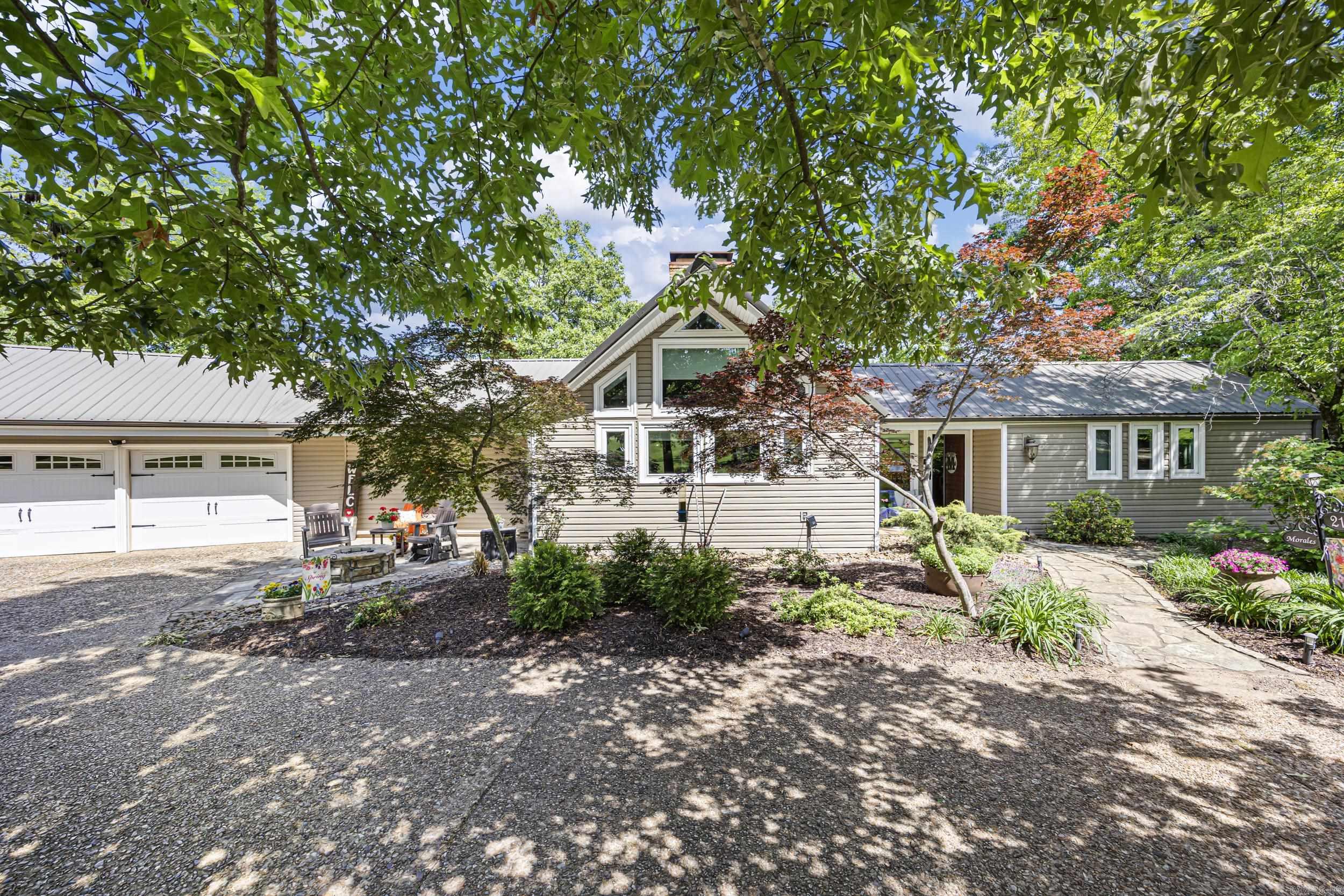 This pristine front yard sets the tone for your own private paradise. From the moment you step inside, the warmth and craftsmanship of this beautiful home are unmistakable. Floor-to-ceiling windows frame uninterrupted views, while soaring ceilings, exposed wood beams, and hardwood floors create an inviting, timeless atmosphere. The classic kitchen adds to the home’s enduring character, making every guest feel welcome.