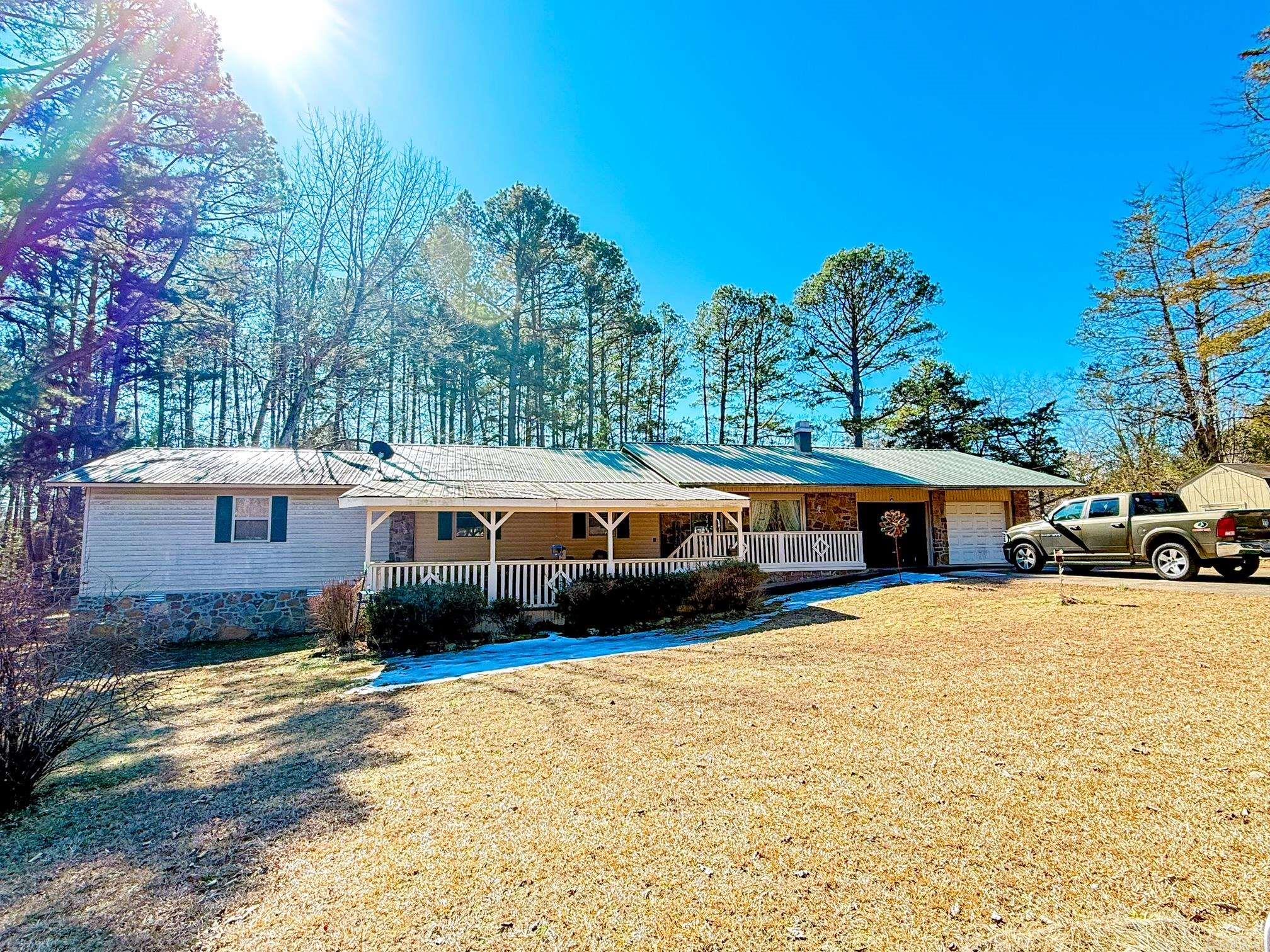 This spacious 4-bedroom, 3-bath home offers approximately 2,240 square feet of versatile living space and a metal roof. Inside, the natural stone wood-burning fireplace serves as a standout feature, adding warmth and character to the main living area. A large laundry room enhances everyday functionality, while the 2-car garage provides convenient parking and storage. Outdoor features include a screened-in porch and a nice deck, creating multiple options for relaxing or entertaining. The property offers two fenced backyard areas, a large front yard, and a desirable corner-lot setting. Multiple storage sheds and a storm shelter add valuable utility and peace of mind, making this property well-rounded both inside and out. Measuring is recommended. AGENTS READ REMARKS