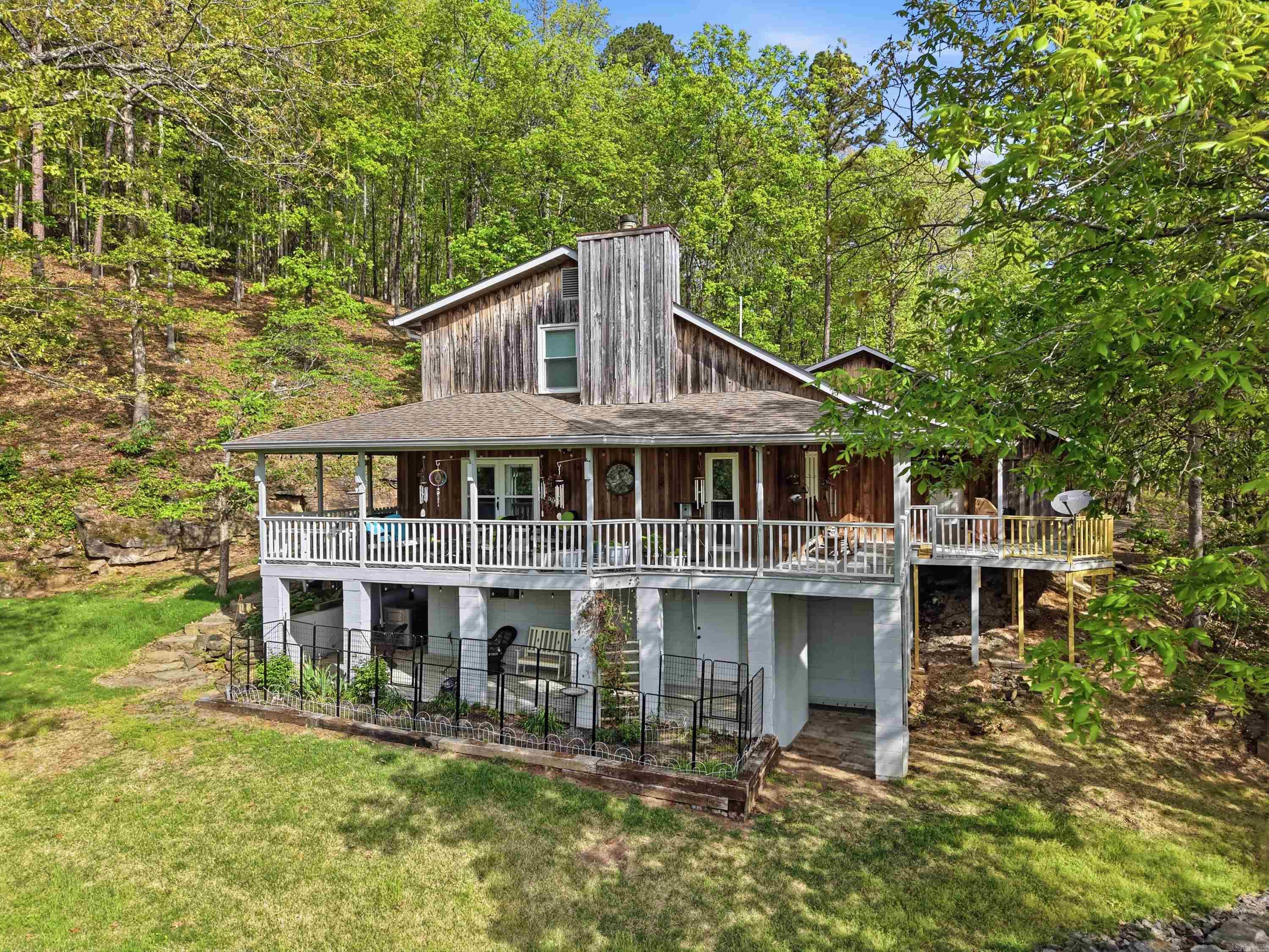 Seller has been original owner since she had the home built in 1991. Cypress Siding (no staining needed, she's only had to pressure wash occasionally). Home is on city water, has backup on demand Generator (under deck), New Furnace installed about 5 years ago & there are geothermal lines that work for heating & cooling located near propane tank (See agent remarks on how that works), Electric water heater, dryer (gas), stove (gas), Wood burning stove fireplace, New Architectural Roof installed by Stephen Ganus about 7 years ago , all new windows installed by Wilson's Windows, & Concrete Boat Ramp located at the end of Leech Rd. (just a short walk from the house) and ramp located in the back of Greers Ferry Lake. Wrap around deck on the backside of home overlooks the lake & seller has plenty of birds & wildlife that comes around with this being tucked into the mountain & surrounded by woods. Basement Area is heated & cooled and could be finished out for more living space. (See measurements under docs from appraiser & See survey of the .85 section being sold off). See "virtual tour website" for the house layout and video of the property