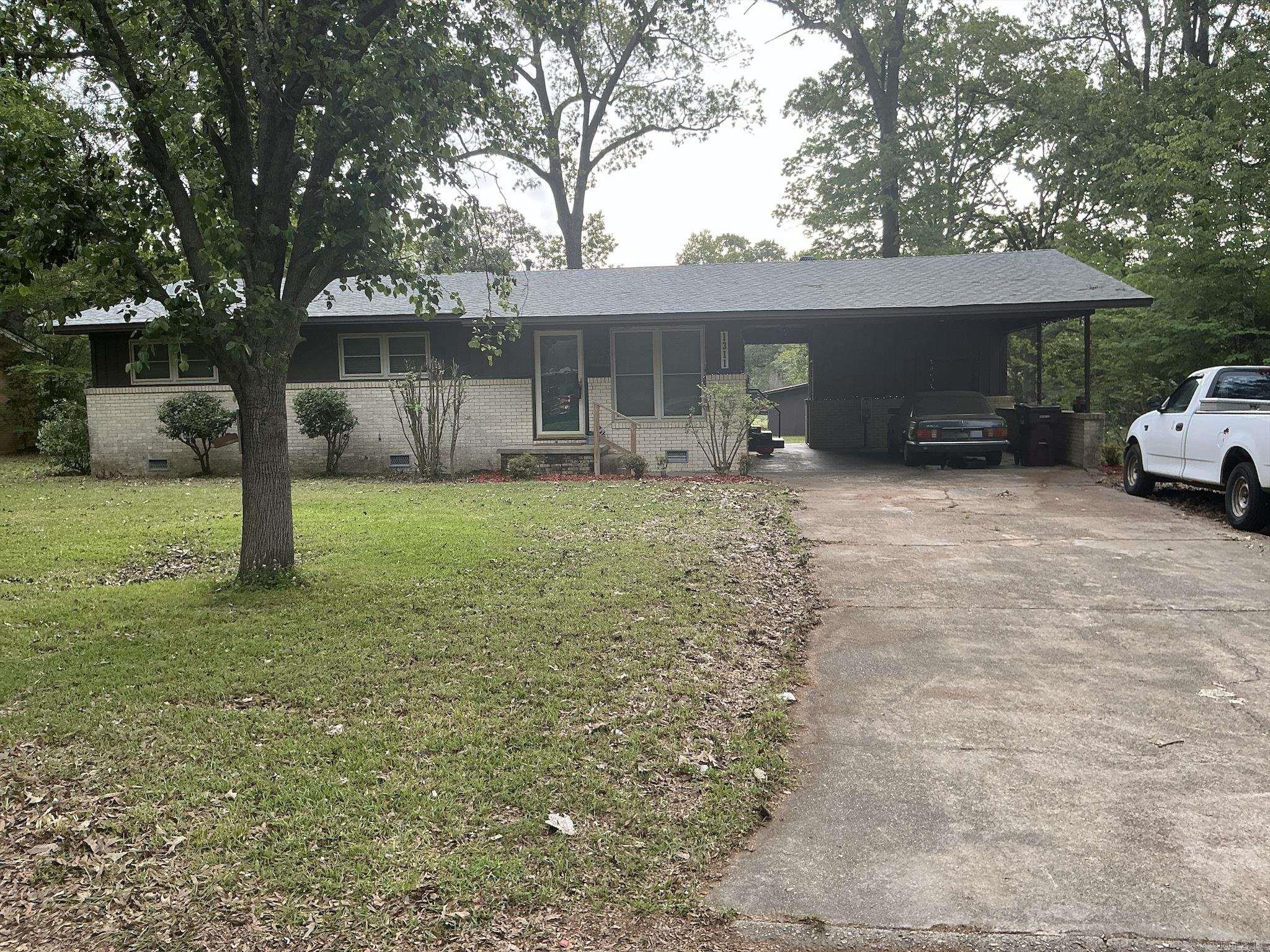 Lovely home featuring formal living/dining room and a large den with fireplace,(heater in front of fireplace now hooked to gas making it easy to install gas logs), vinyl flooring in the galley kitchen with refrigerator and stove and a eating area.  In the living room, hallway and three bedrooms have beautiful hardwood floors.  The three bedrooms have good size closets also.  The hall bath has a walk-in shower and the master bedroom has a half-bath.  Home has central heat and air, laundry room is in storage roof off the double carport, and another storage room off double carport.  The large backyard is fenced and has large shop.  This is one home you must see to know all the features.