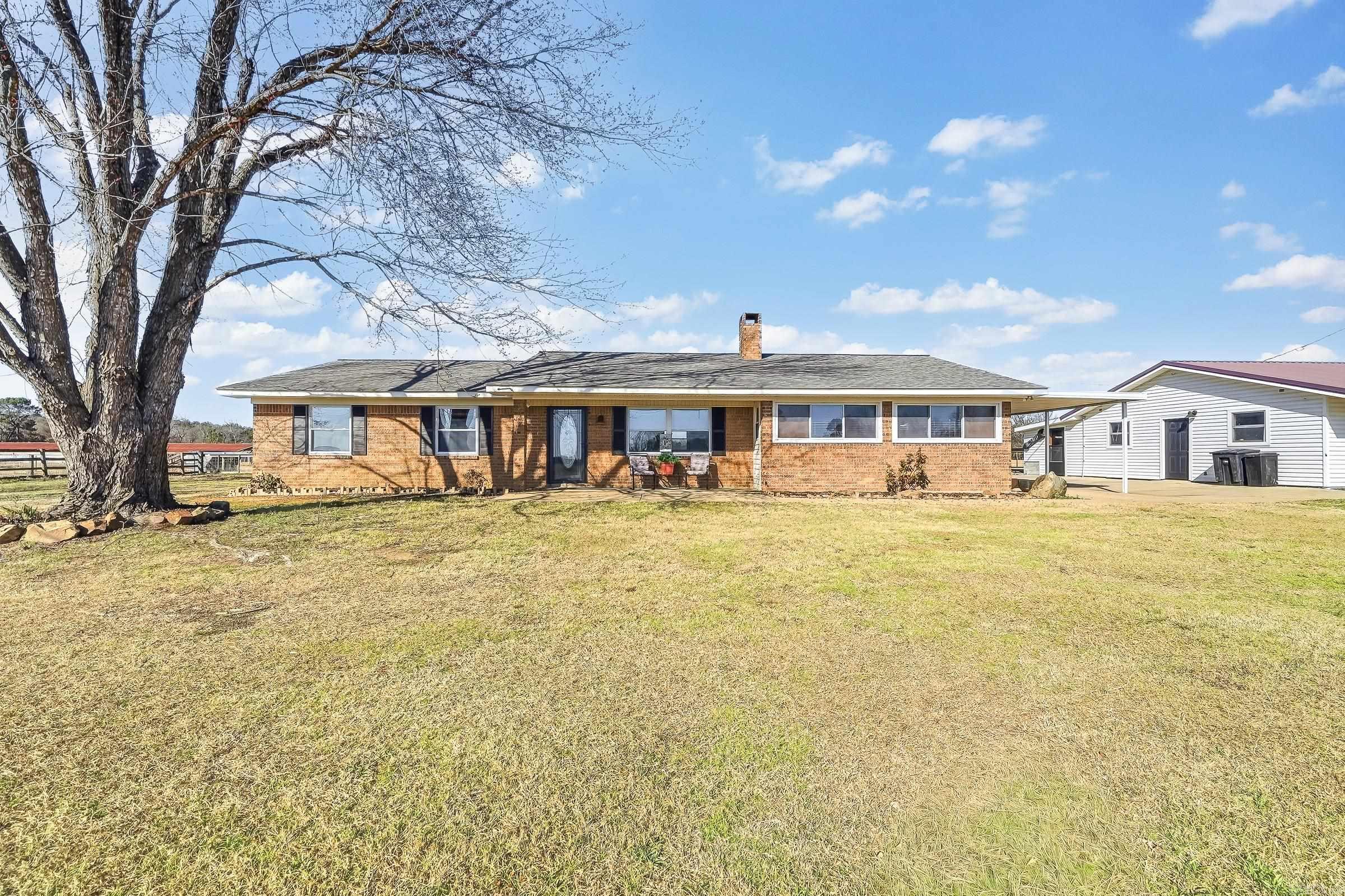 This home has so much to offer for the family that likes to live outside and inside!    A brick home that has 1907 square feet with 3 bedrooms and 2 bathrooms, laundry room with a pantry/closet, a large bonus room, a carport to pull up into when it is raining! The 2-car garage with a connecting bedroom, bathroom, and a large closet sits close to the home.  Summer is here so you need a pool! The inground pool has a very unique entrance and it is heated! An outdoor kitchen is right there.  On the end of the pool there is a Cabana with a fire pit!  Oh and a place for your hot tub! A truly must see home! All of this for $299,000! If you would like more there are 14 acres with two chicken houses that could be used for storage or maybe shops! Lots of room! Newly built pond that is 13 feet deep in the middle. Of course you need a barn so it has one closer to the home. There are several options!