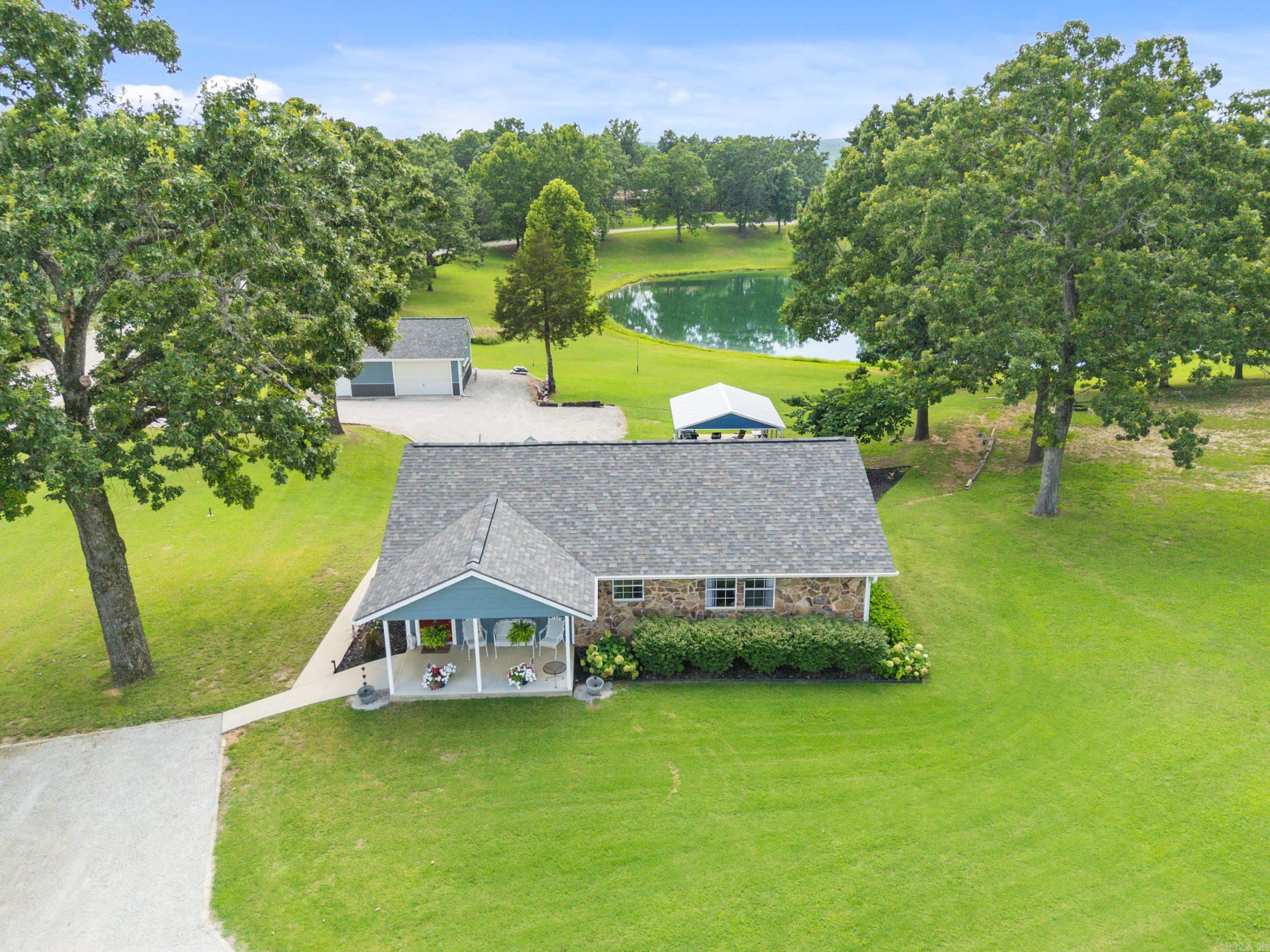 Experience the perfect blend of privacy, beauty, and convenience on this meticulously maintained 3.1 ac m/l property, just 10 minutes from town and only 1 mile from Pigeon Creek public boat launch. Nearly the entire home was remodeled in 2018, with a brand-new roof and deck in 2025. Step outside to a stunning pond just beyond your back door, with a private deck o the primary bedroom o ering peaceful water views. The beautifully landscaped grounds feature hydrangeas, gardenias, Chinese maples, and more. Enjoy outdoor entertaining under the 18x20 pavilion with a concrete pad, ideal for cooking and gathering. An insulated detached shop with electric and water adds exceptional functionality. Truly one of a kind, this serene retreat checks all boxes while providing unforgettable charm!
