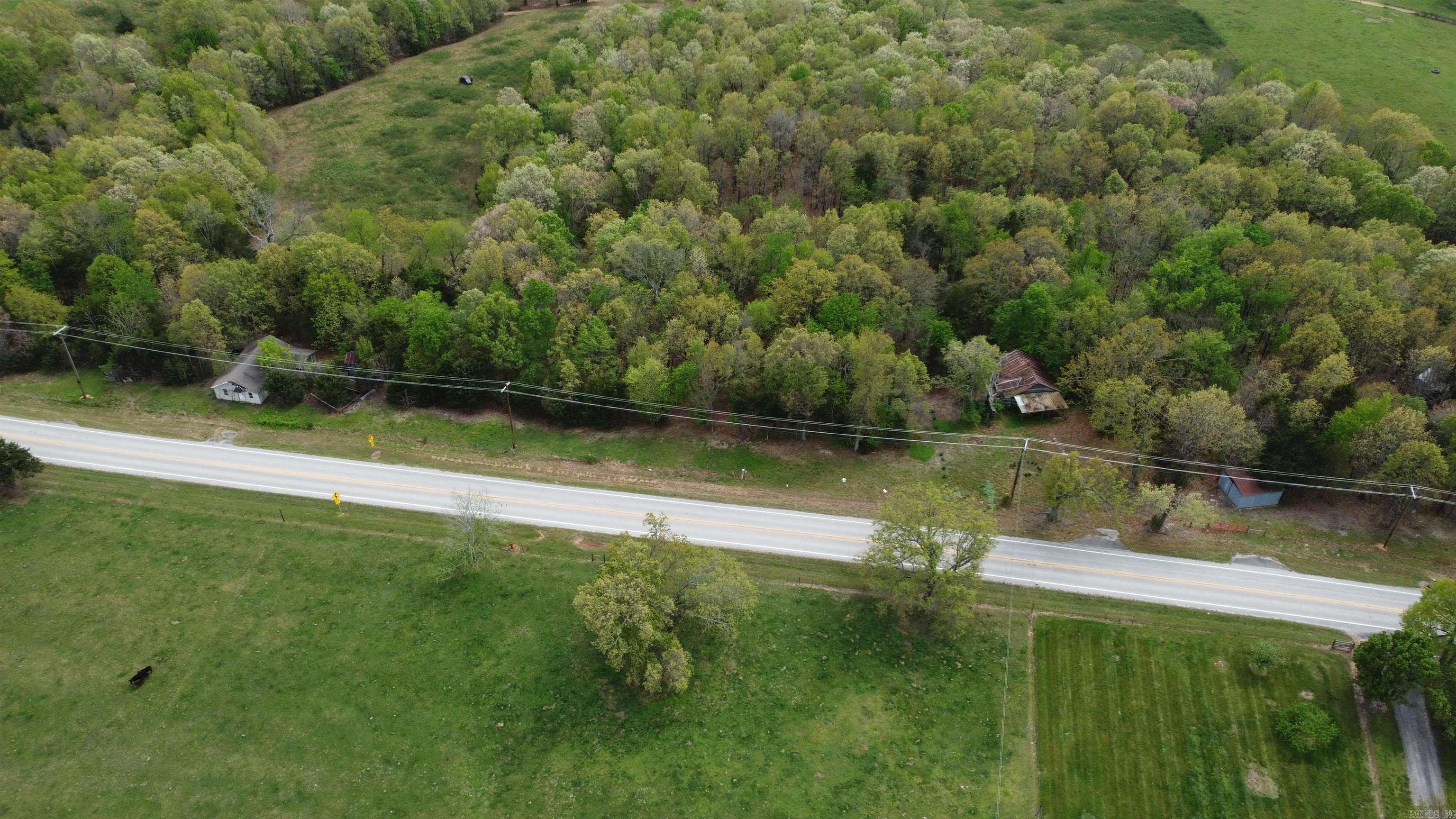 4± Acres with 1,100 Ft of Highway 27 Frontage - Endless Potential Near the Buffalo River  Unlock the possibilities with this ideally located 4± acre property featuring approximately 1,100 feet of prime Highway 27 frontage. Whether you're looking for an investment opportunity, a business venture, or a private getaway, this versatile tract is ready to bring your vision to life.  The property includes two existing homes and a cabin of no monetary value, metal shop building with concrete floor and already has water and electric in place, with fiber internet available-giving you a valuable head start for development. With ample space, this land is perfectly suited for RV sites, cabins, short-term rentals, multiple homes, or even a small commercial venture.  Located just minutes from the stunning Buffalo National River and the charming town of Marshall, you'll enjoy the perfect balance of convenience and seclusion. This property offers peaceful surroundings while still being close to one of Arkansas's top outdoor destinations.  Possible Owner Financing Available!!!