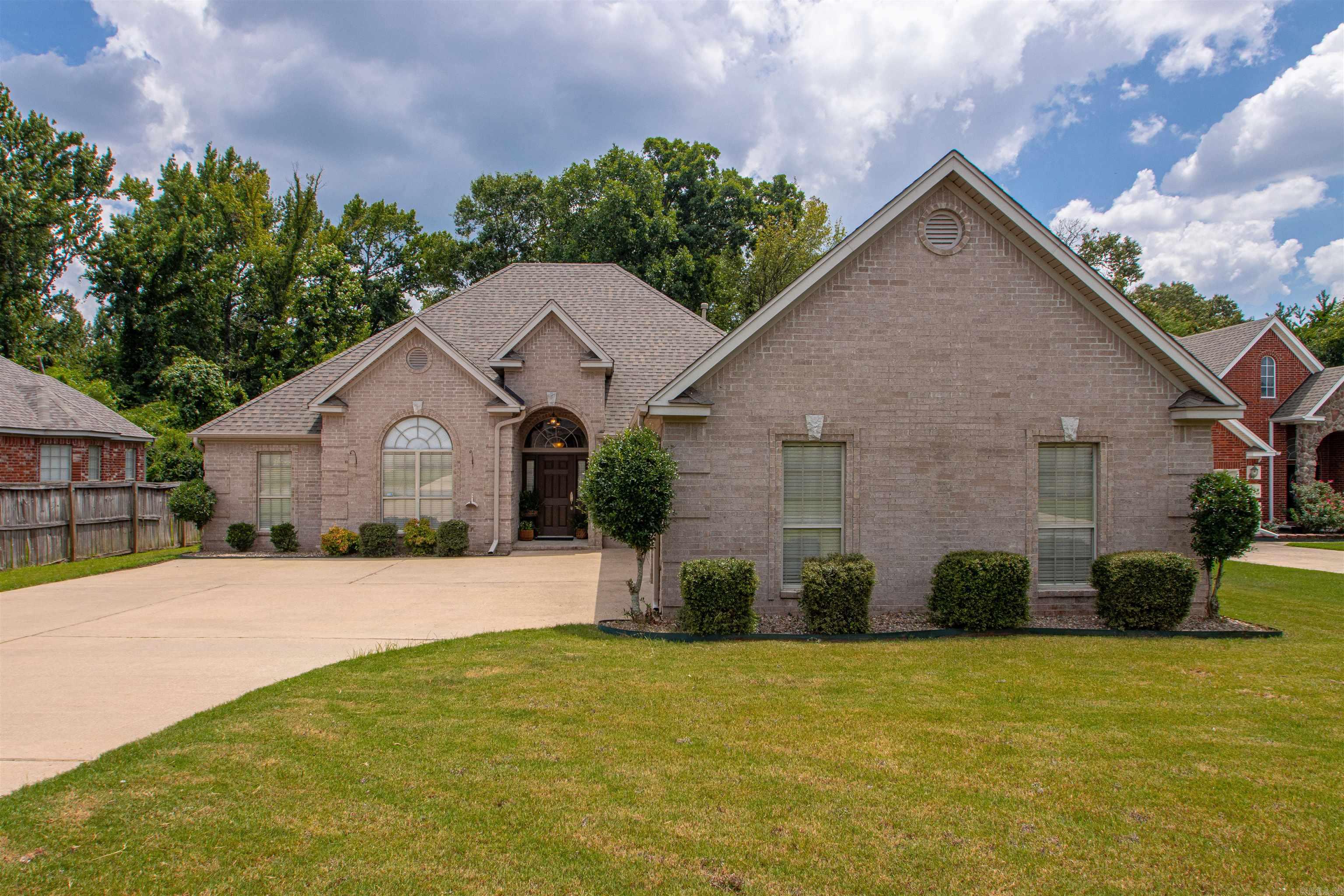 Tucked away on a quiet cul-de-sac in the Stonehill Subdivision in Sherwood, this move-in-ready brick home offers the perfect blend of comfort, flexibility, and privacy with no rear neighbors. The well-designed floor plan features 4 bedrooms and 2 baths, with the fourth bedroom easily serving as a dedicated home office. Fresh interior paint throughout and brand-new carpet in the bedrooms complement the tray ceilings, extensive crown molding, and luxury vinyl plank flooring throughout the main living areas. The spacious living room features a double-sided electric fireplace shared with a large bonus living area, creating two inviting spaces for relaxing or entertaining. The kitchen offers painted cabinetry, Corian countertops, an extended breakfast bar with seating, a breakfast area, and a separate formal dining room. The oversized primary suite provides private access to the covered back porch and includes an ensuite bath with French doors, a jetted tub, separate shower, dual vanities, and two walk-in closets. Step outside to enjoy the peaceful backyard, which backs to a wooded green space and tranquil creek, providing exceptional privacy. The covered back porch and additional patio
